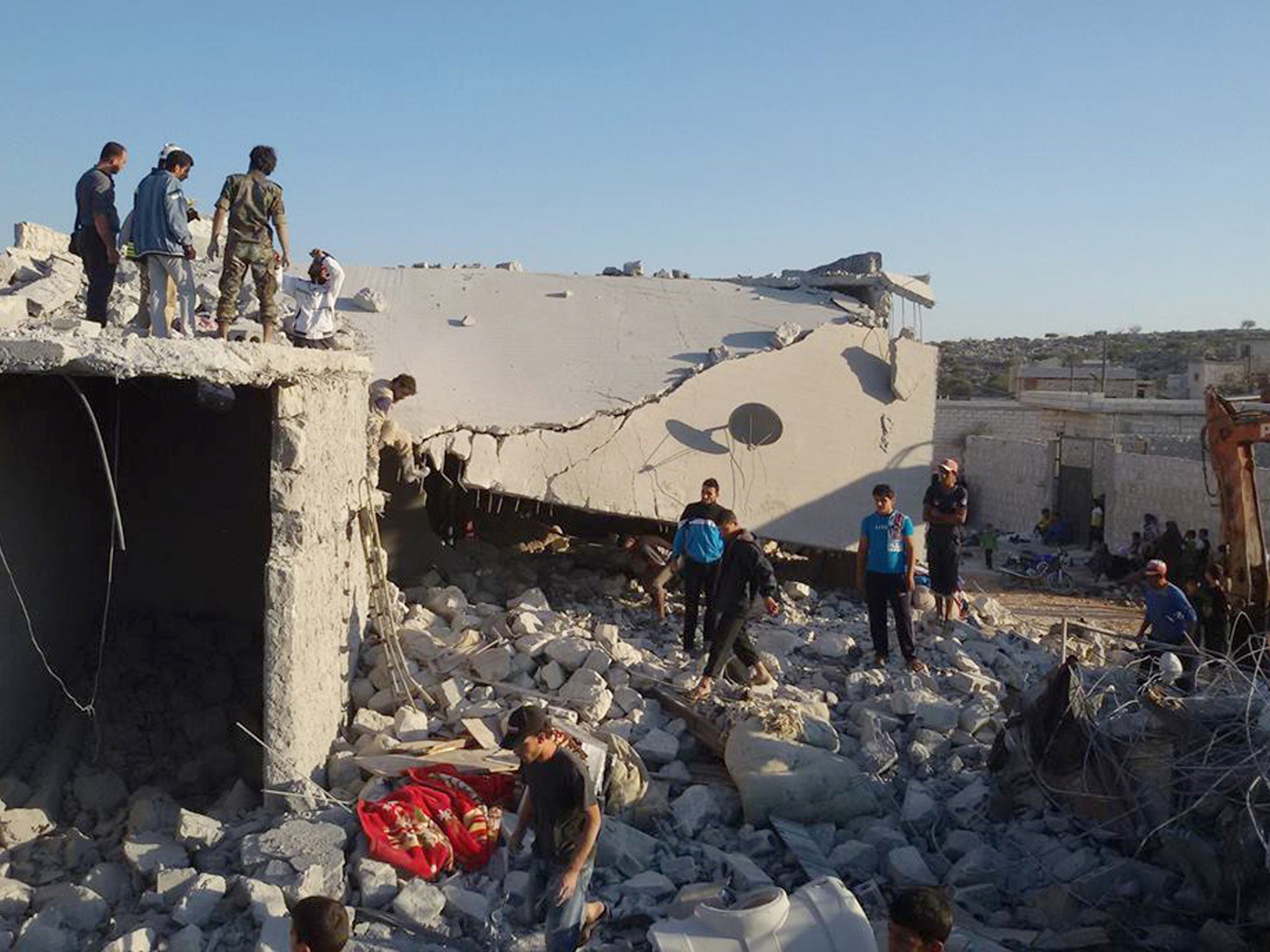 Syrian citizens check a damaged house that targeted by the coalition airstrikes, in the village of Kfar Derian, a base for the al-Qaida-linked Nusra Front, a rival of the Isis group, between the northern province of Aleppo and Idlib