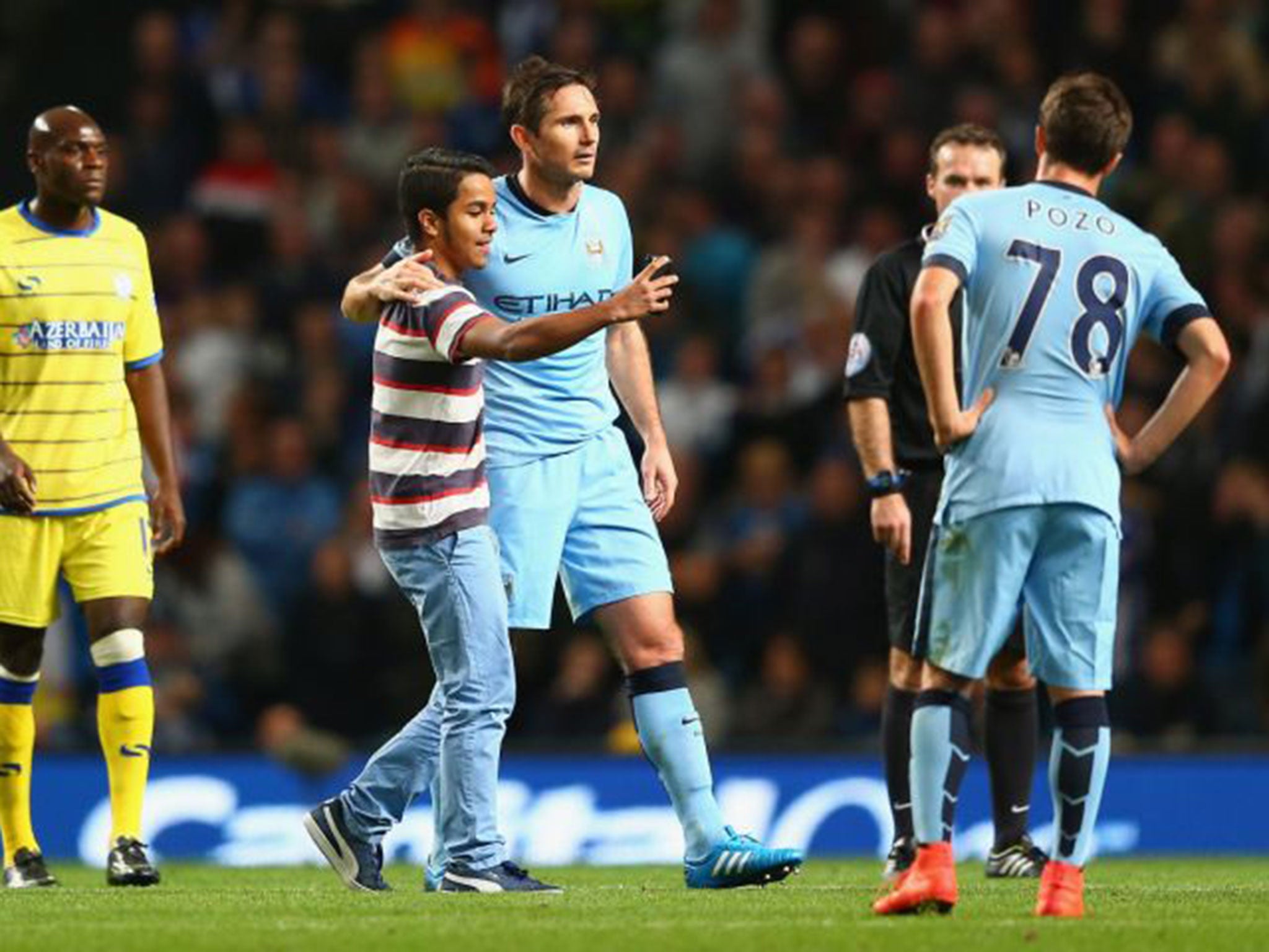 A fan who ran on the pitch during the game takes a selfie with
Frank Lampard. He was promptly arrested for his troubles