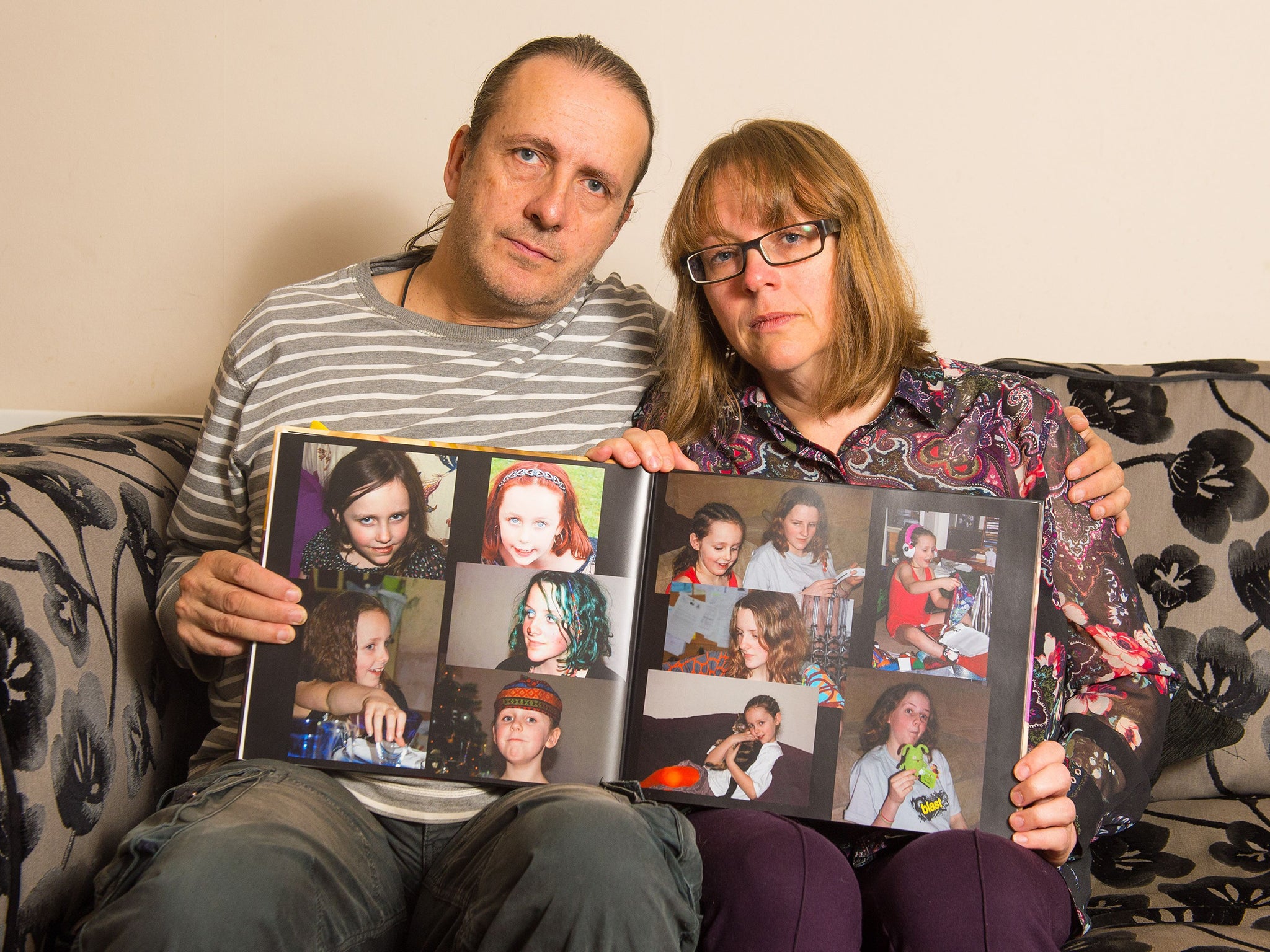 Jose Gross and Rosalind Hodgkiss, the parents of missing teenager Alice Gross holding an album of photos of her at their home in Hanwell, west London