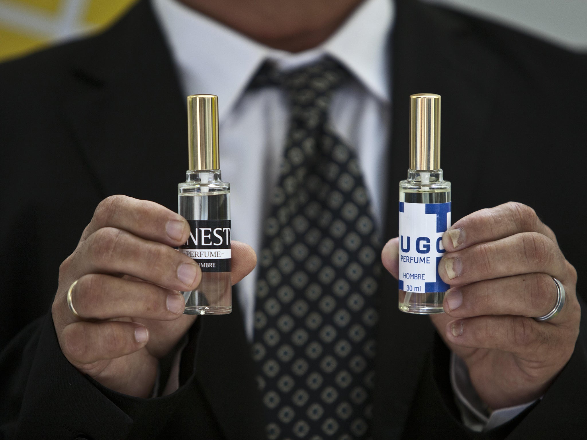 A man shows two bottles of cologne, one called "Ernesto," honouring Ernesto "Che" Guevara, and "Hugo" for Hugo Chavez