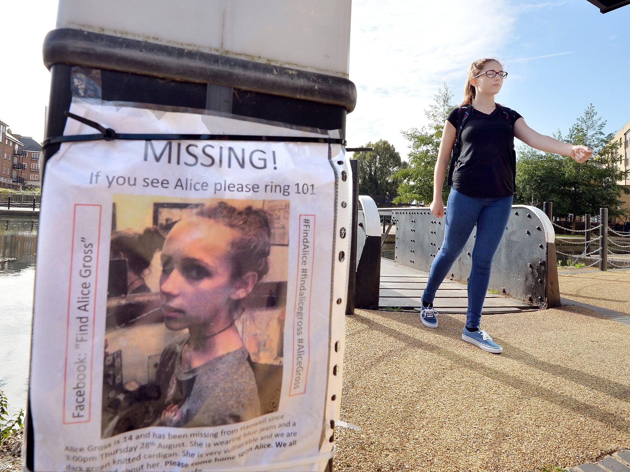 A police cadet walks across the bridge at the Brentford Locks as part of the reconstruction of the last known movements of missing schoolgirl Alice Gross