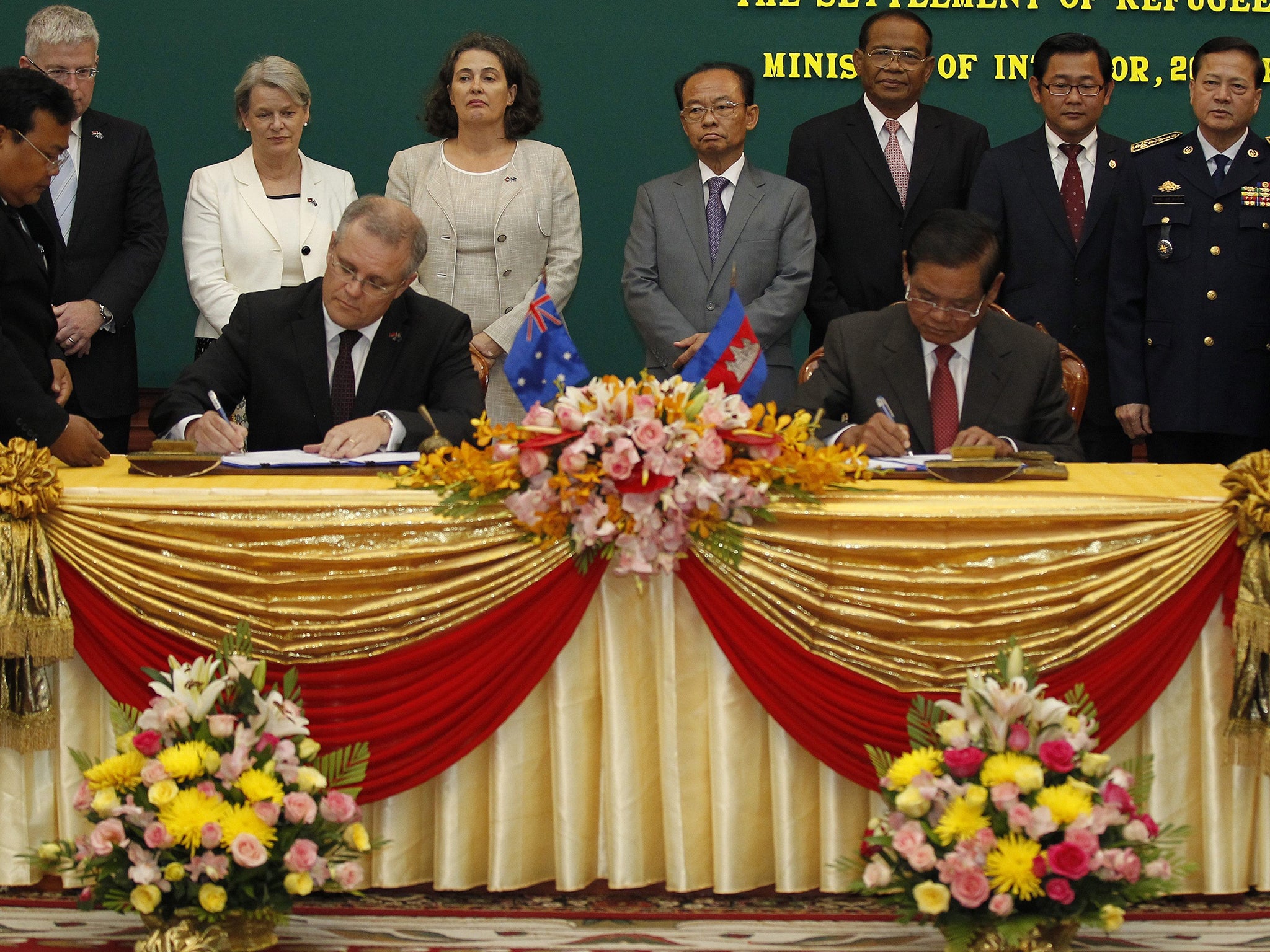 Scott Morrison (left), Australian Immigration Minister, and Sar Kheng (right), Cambodian Deputy Prime Minister and Minister of the Interior, sign an agreement in Phnom Penh