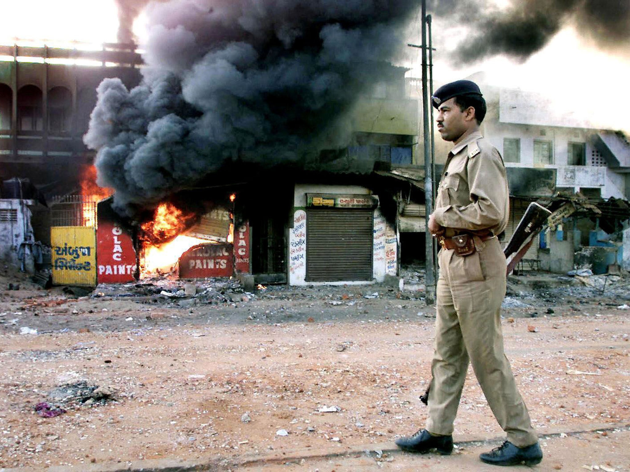 A policeman patrols during deadly religious riots between Hindus and Muslims in the state of Gujarat in 2002, when the current Prime Minister Narendra Modi was its chief minister