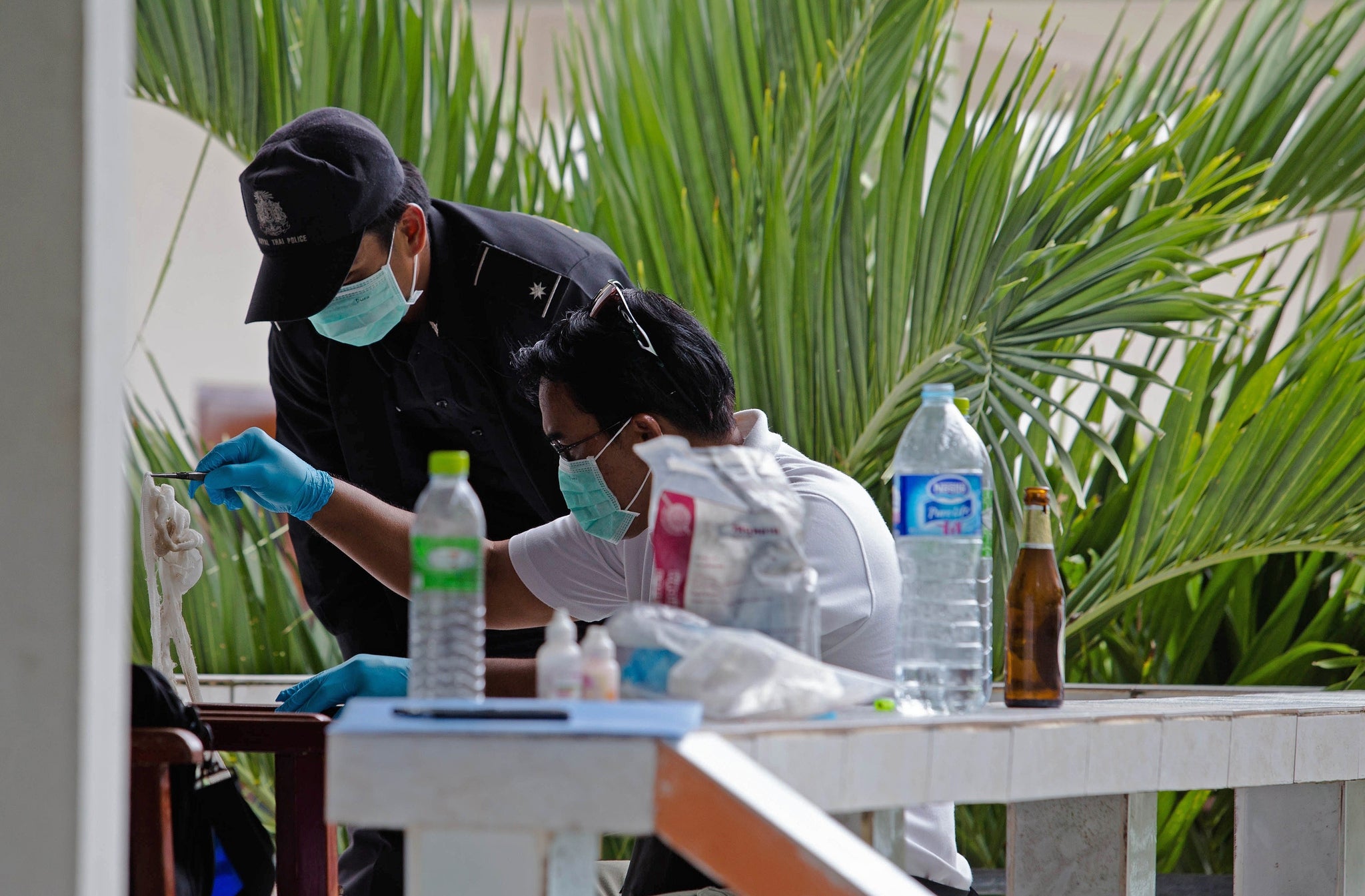 Thai forensic investigators inspect a hotel room