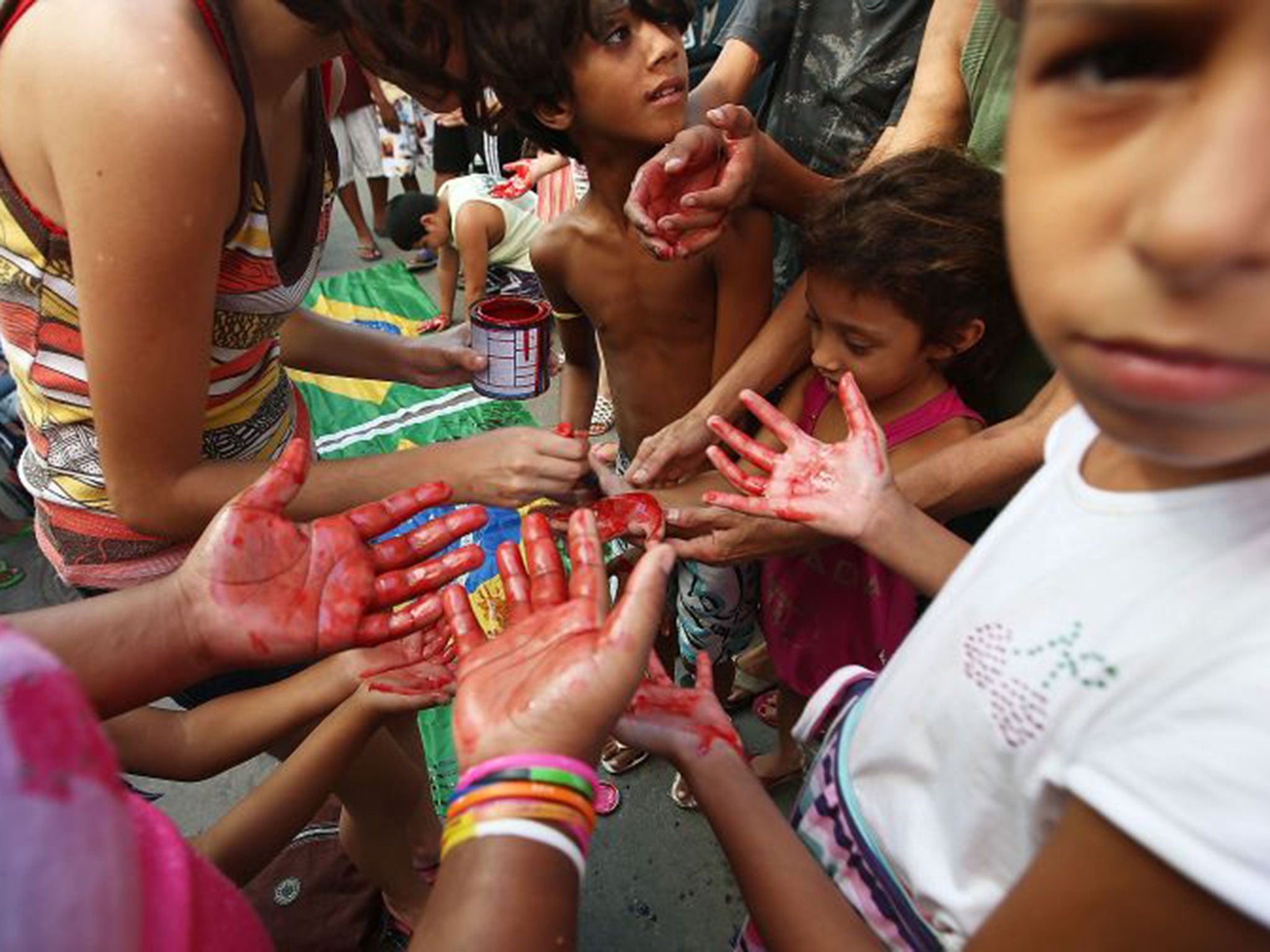 Children paint their hands red to symoblise the blood of Maré residents