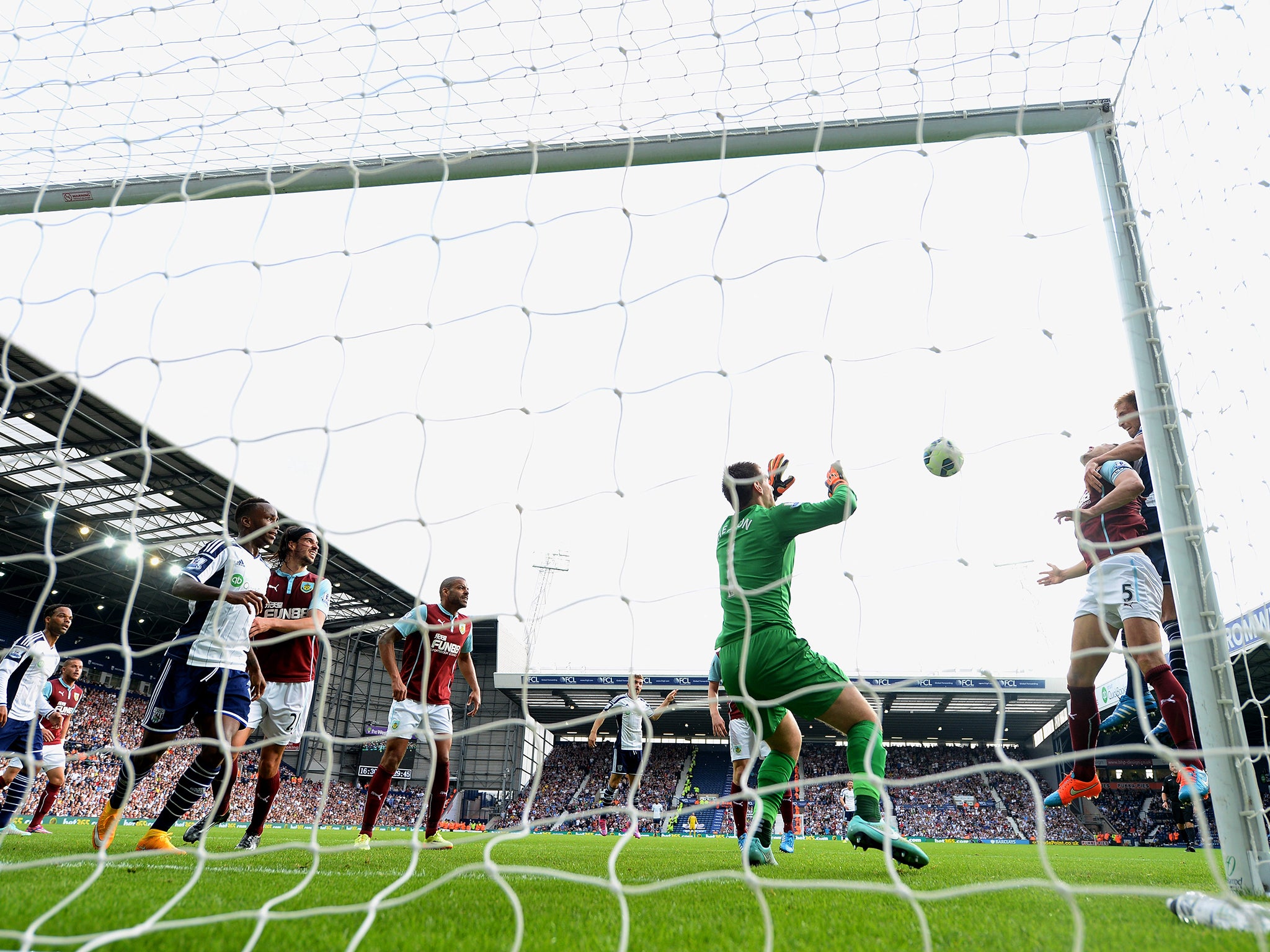 Craig Dawson (R) of West Brom heads the ball past Thomas Heaton of Burnley to score the opening goal