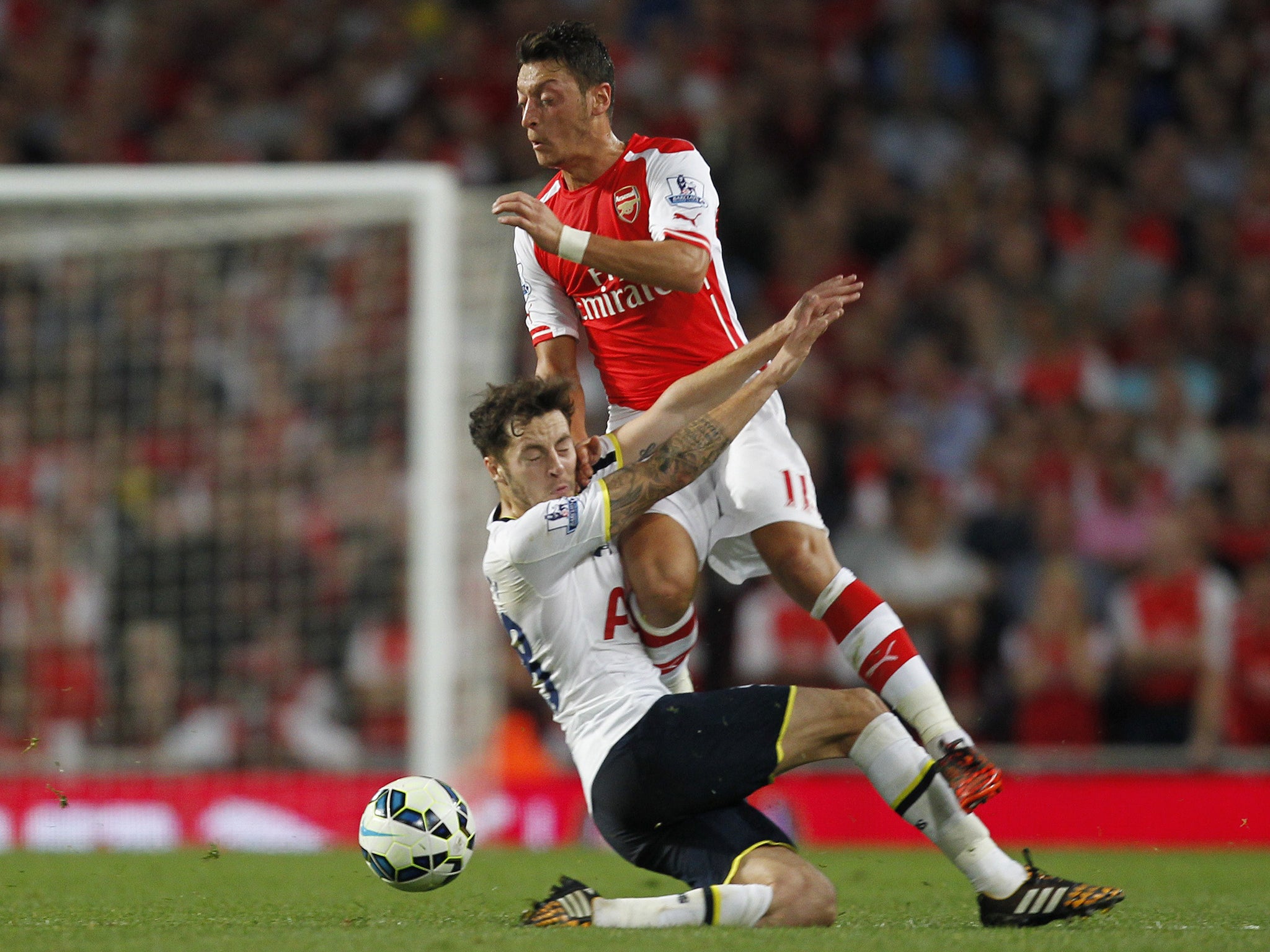 Ryan Mason challenges Mesut Ozil