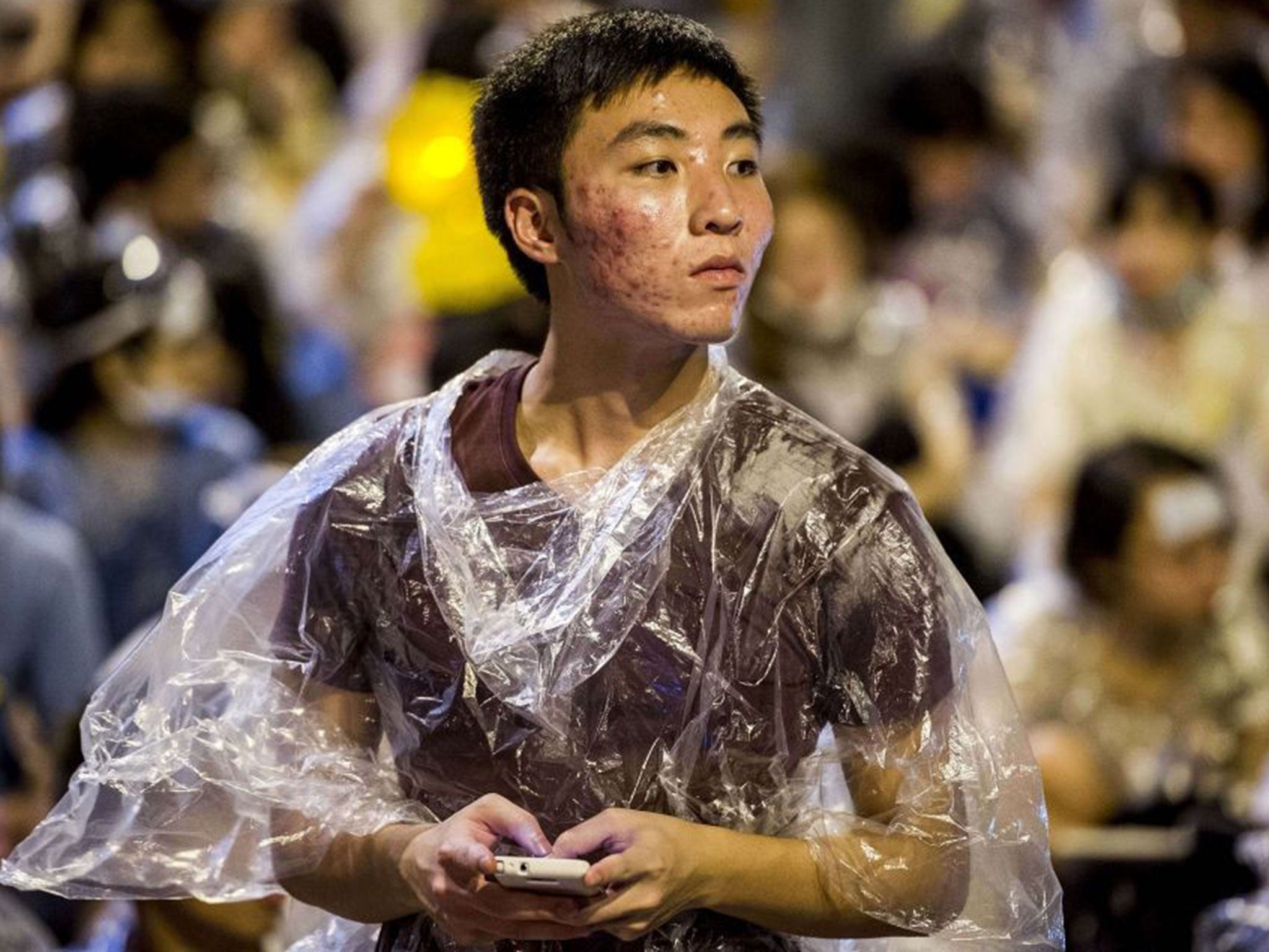 A protestor texts on his phone during a demonstration outside the government headquarters in Hong Kong on September 28, 2014.