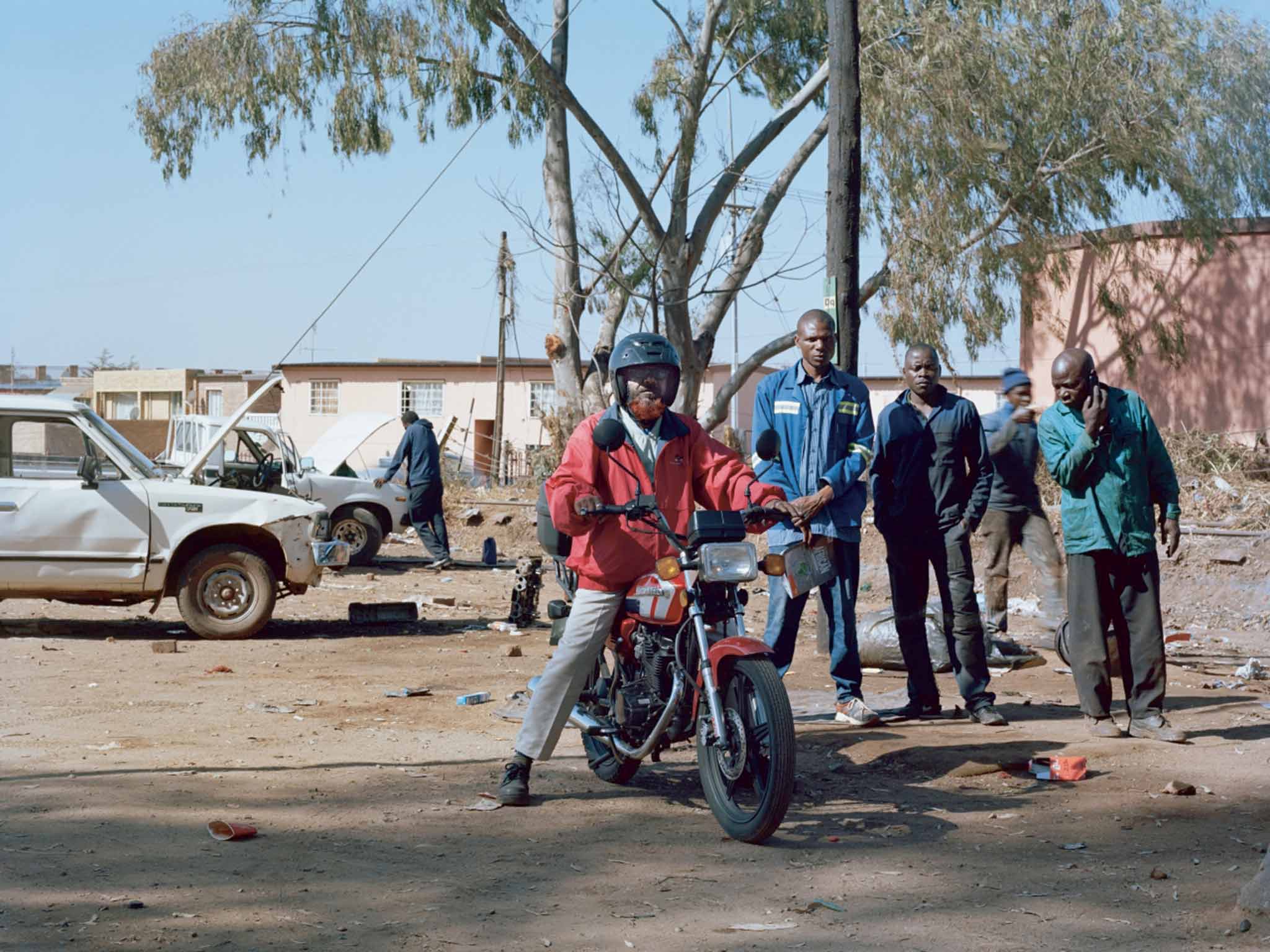 At The Stop Sign (Sajid, Albert, Daniel and Ryngo): "Sajid Husen Pathan moved to South Africa 10 years ago from Gujarat, in India and works as a delivery driver. Daniel and Ryngo run the roadside garage in Laudium."