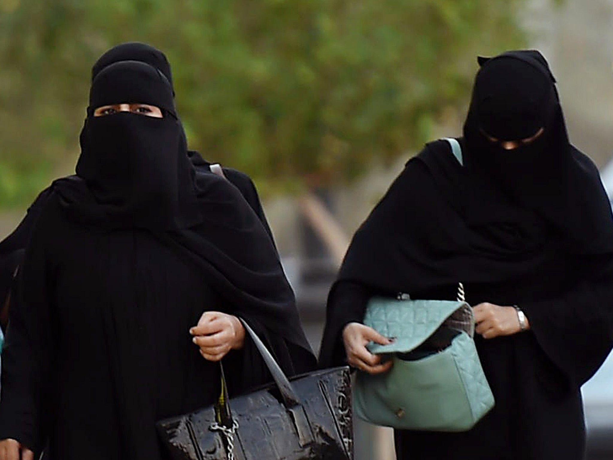 Two Saudi women wearing burkas walk on a street in the desert kingdom's capital Riyadh