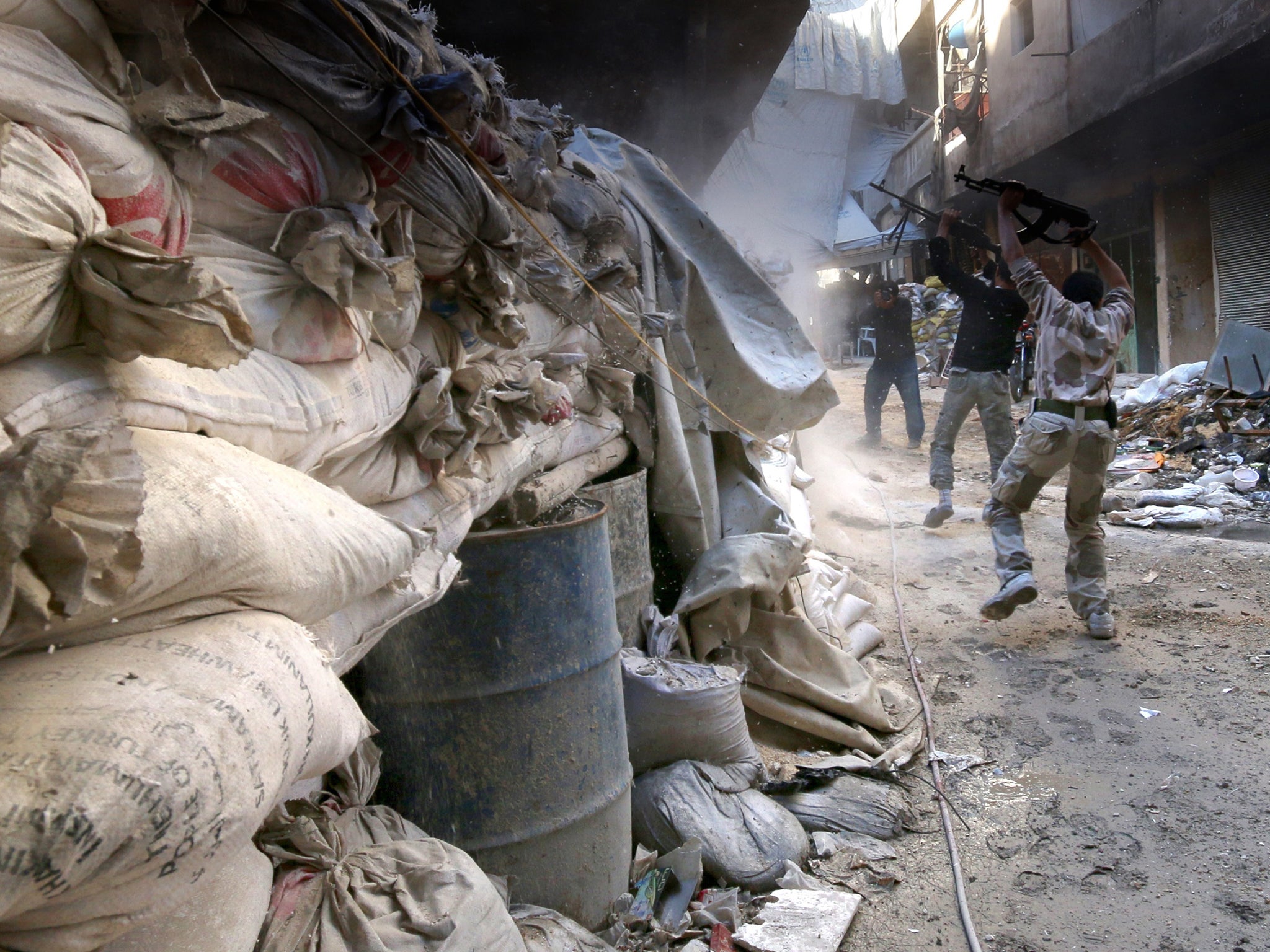 Rebels fire from behind sandbags on a front line in the
al-Amiriya district of Aleppo, Syria