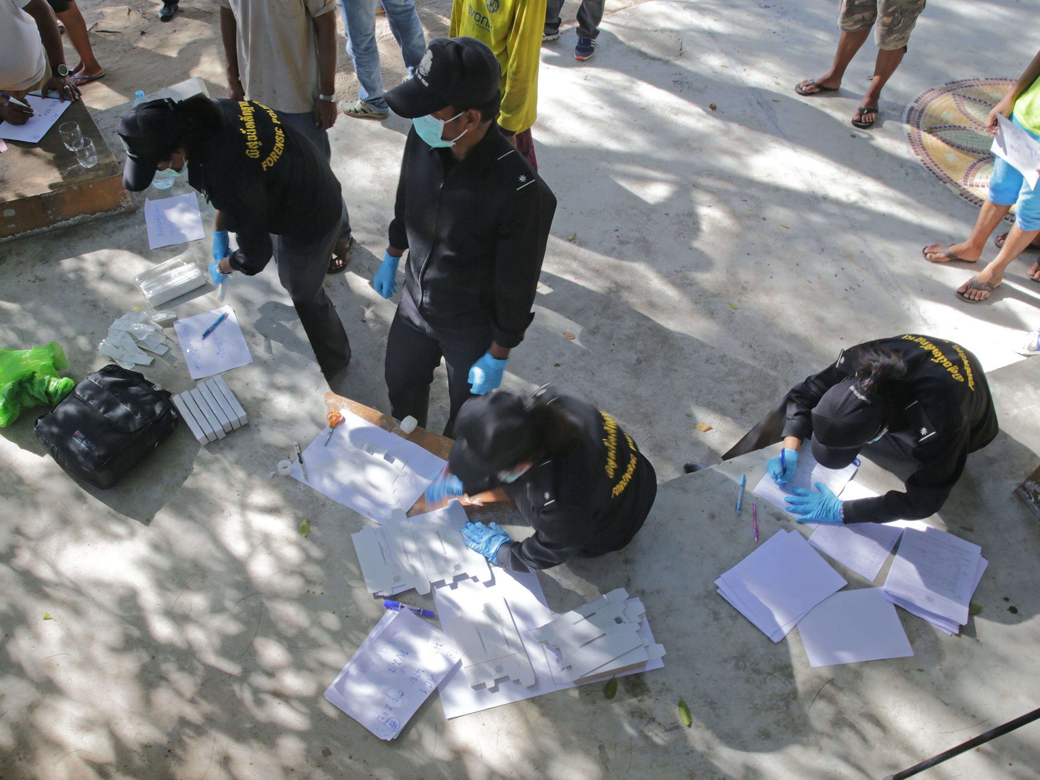 Thai policemen conduct DNA tests on staff from two beachside bars as part of the investigation on the murder of two British tourists on the southern resort island of Koh Tao