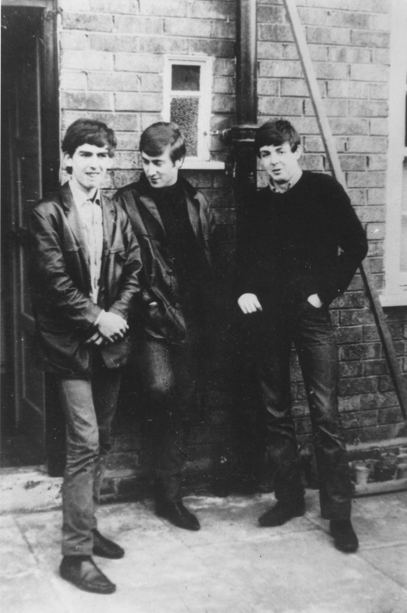 The Beatles stand outside Paul's Liverpool home (left to right) George Harrison (1943 - 2001), John Lennon (1940 - 1980), Paul McCartney