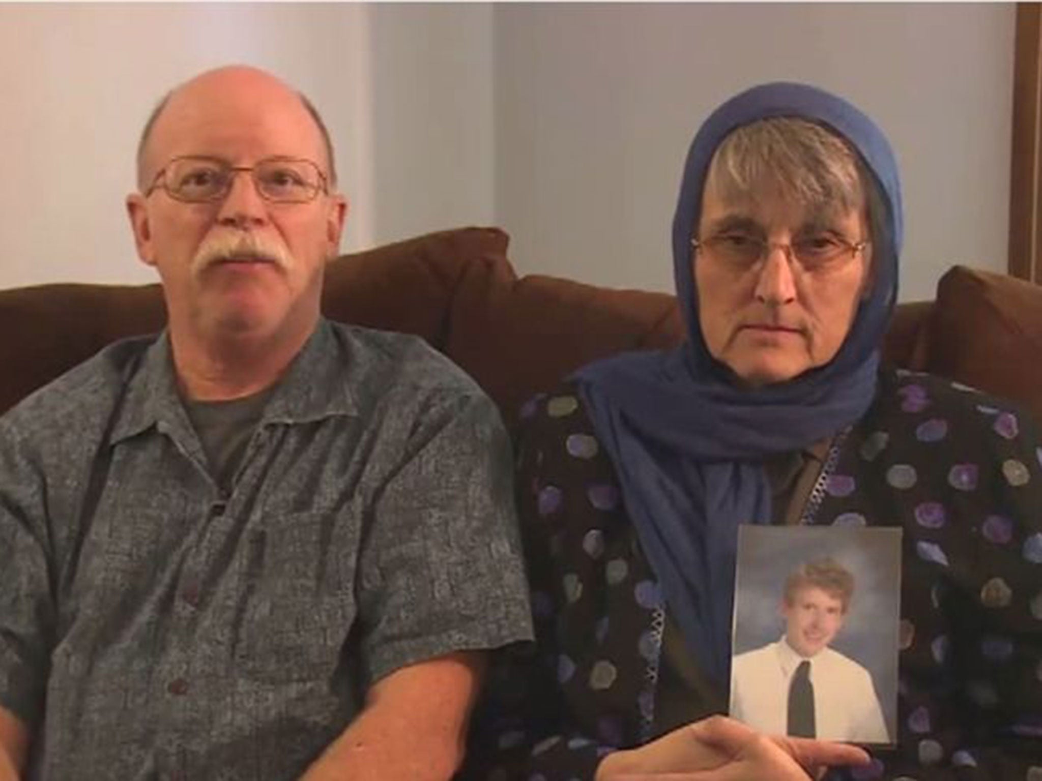 The Kassigs in their video message with a photograph of their son Peter