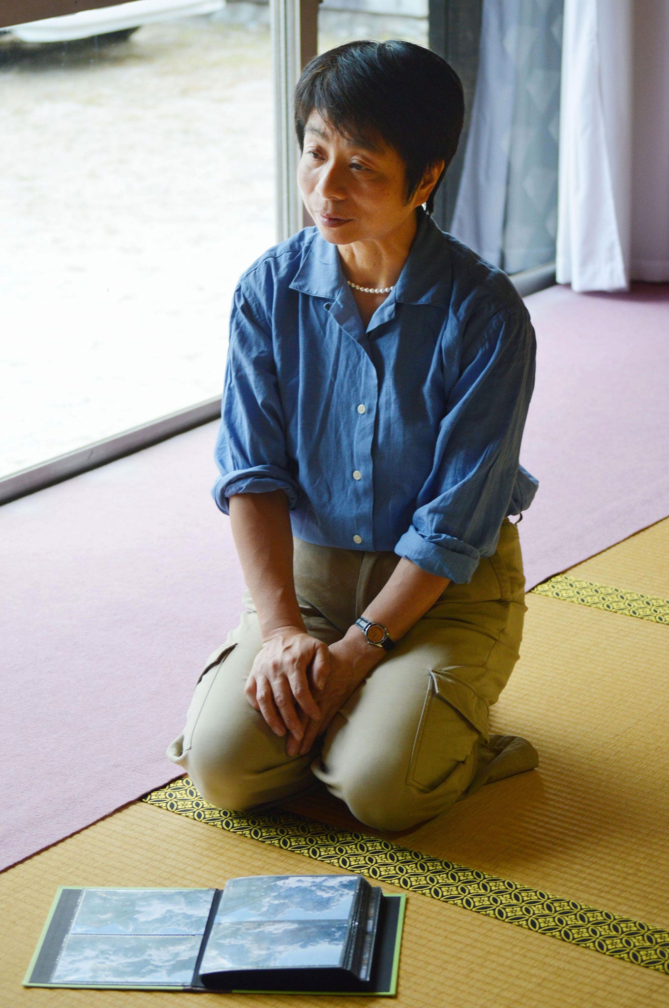 Hiromi Noguchi, wife of 59-year-old hiker Izumi Noguchi who fell victim to the eruption of Mount Ontake, speaks to Kyodo News while showing last photos of the volcanic mountain