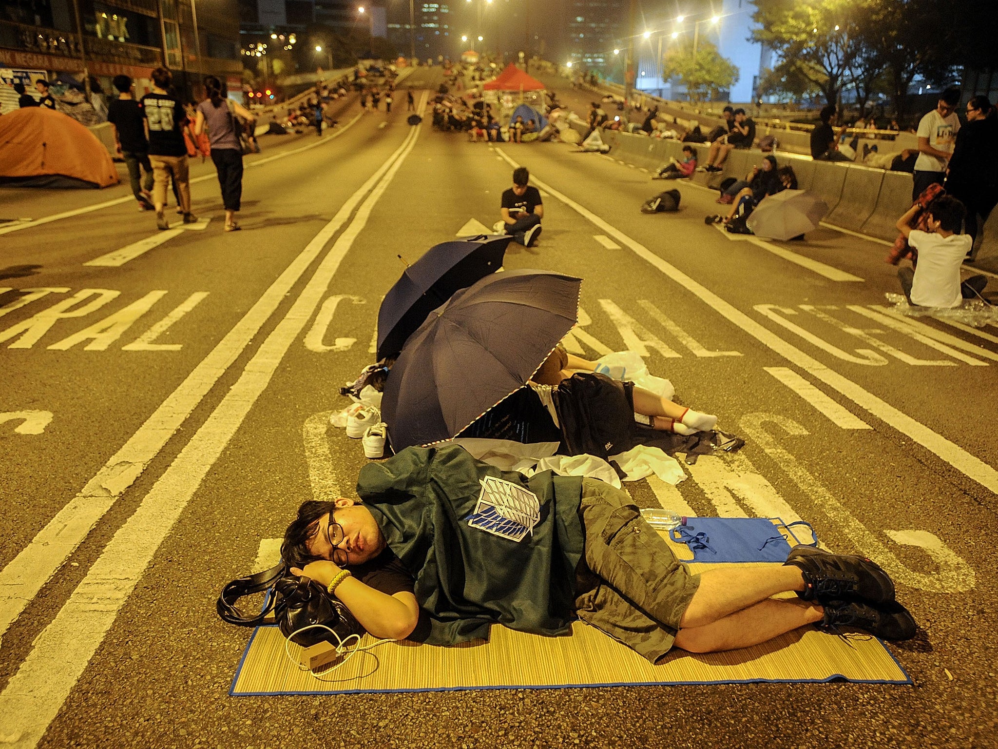 A protester sleeps in the street outside the Hong Kong government building