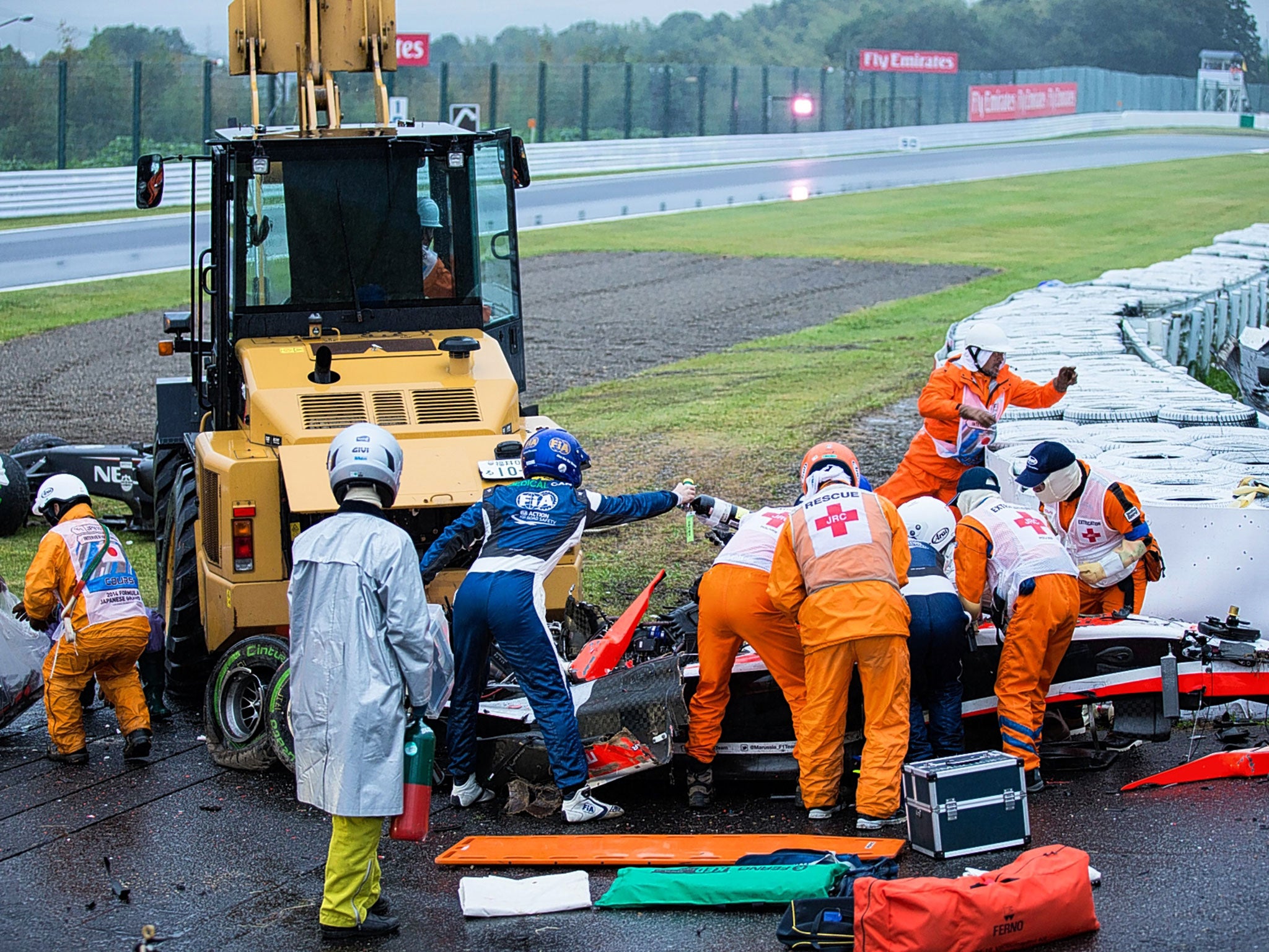 Jules Bianchi receives treatment after smashing into a recovery vehicle