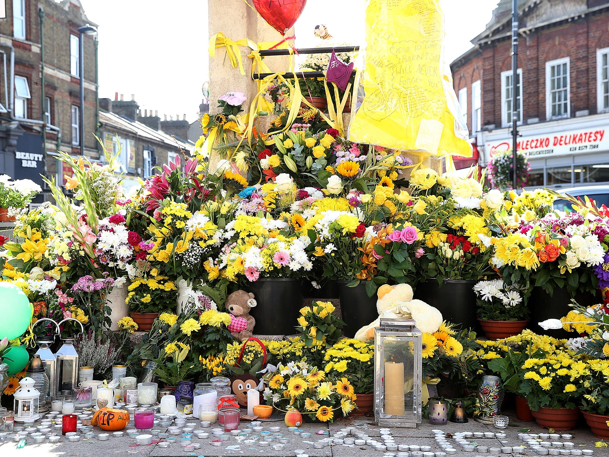 A general view of flowers left at the Hanwell clock tower in memory of Alice Gross in London