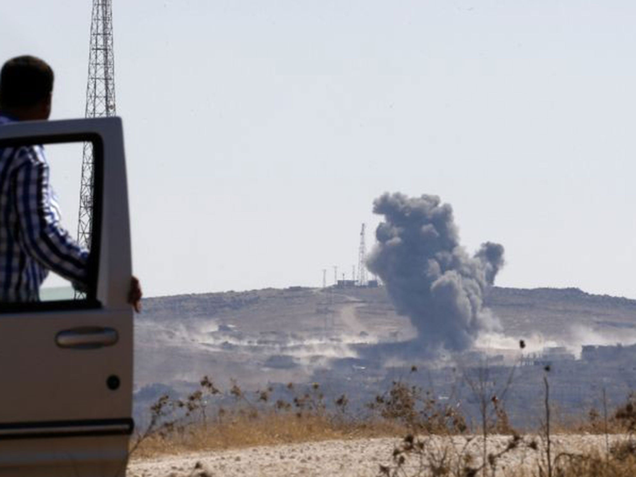 Smoke rises from the Syrian town of Kobani, seen from near the Mursitpinar border crossing on the Turkish-Syrian border on 6 October 2014