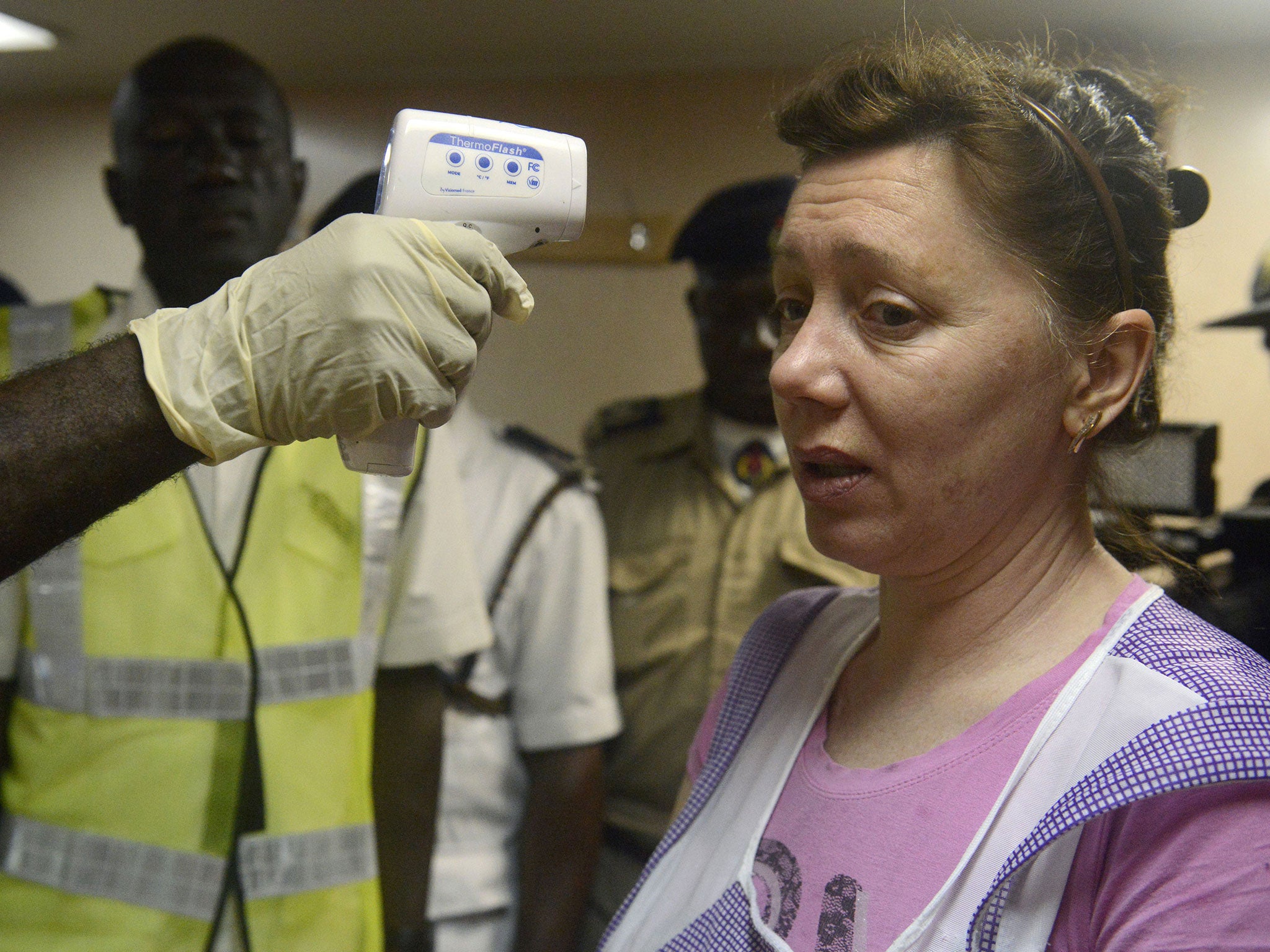 A health official takes the temperature of an Ukrainian worker on the MV Pintail cargo ship in an Ebola check in Lagos