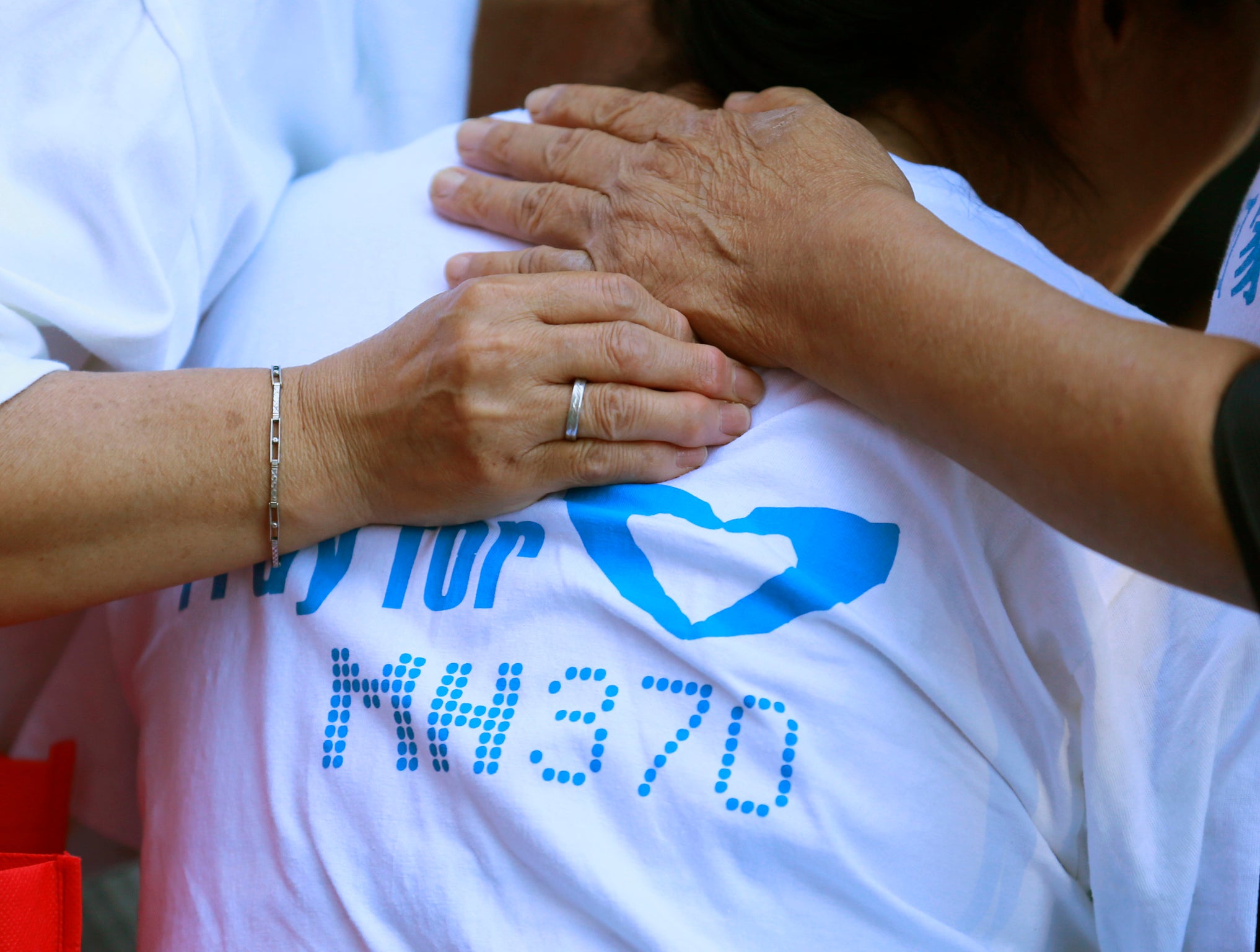 Parents and children release a sky lantern, with a note of prayer written for MH370, on 13 September