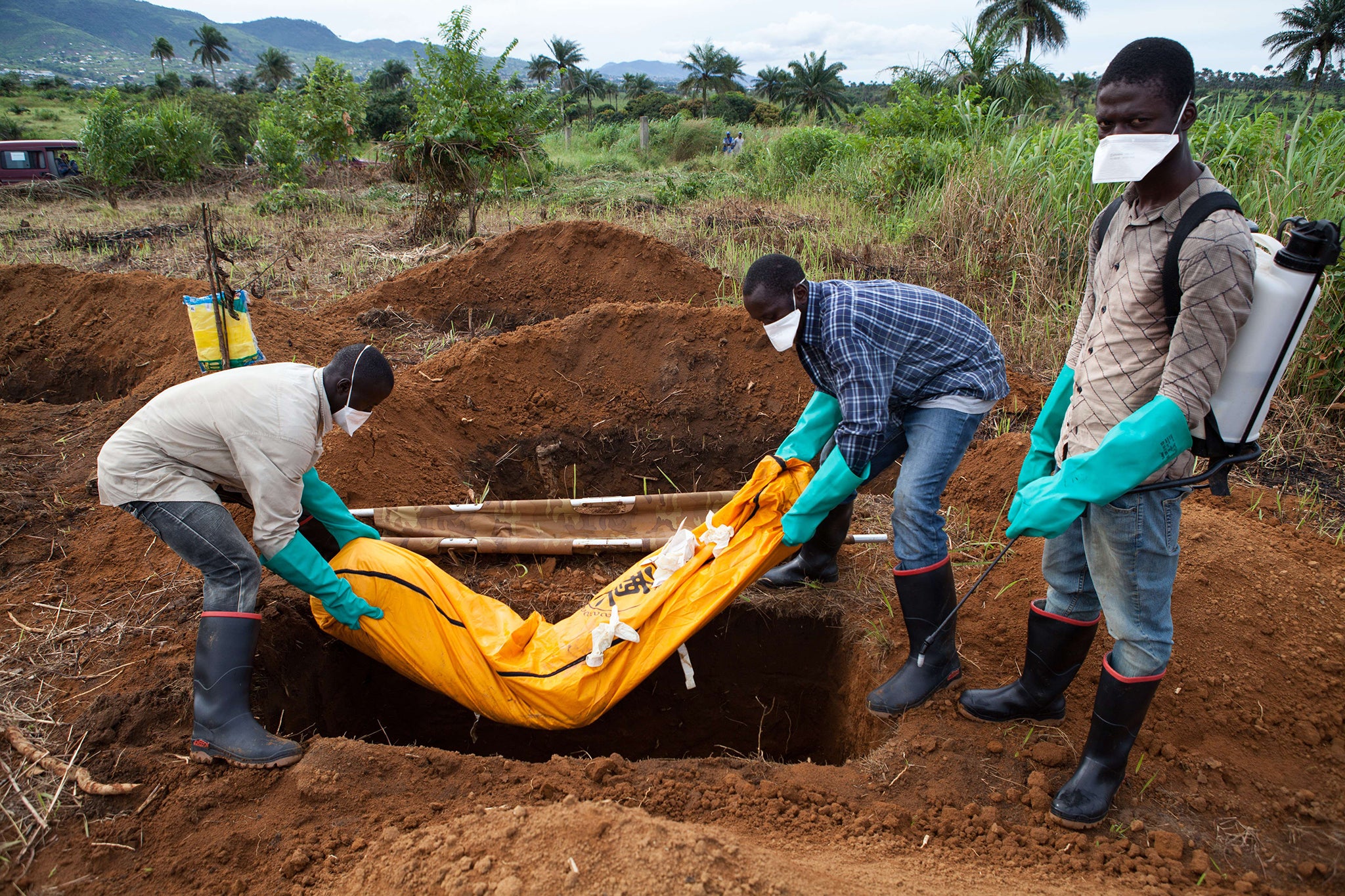 Volunteers in protective suit bury the body of a person who died from Ebola in Waterloo, some 30 kilometers southeast of Freetown