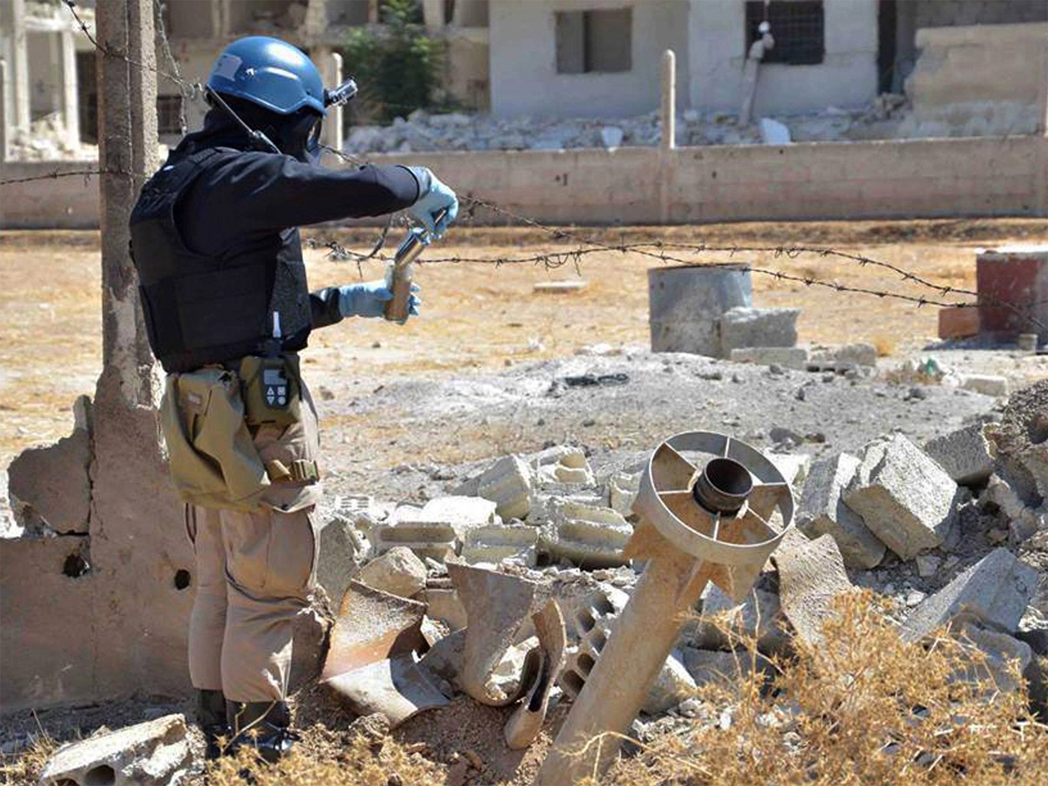 A UN investigator takes samples around a missile found near Damascus suspected of being a chemical rocket