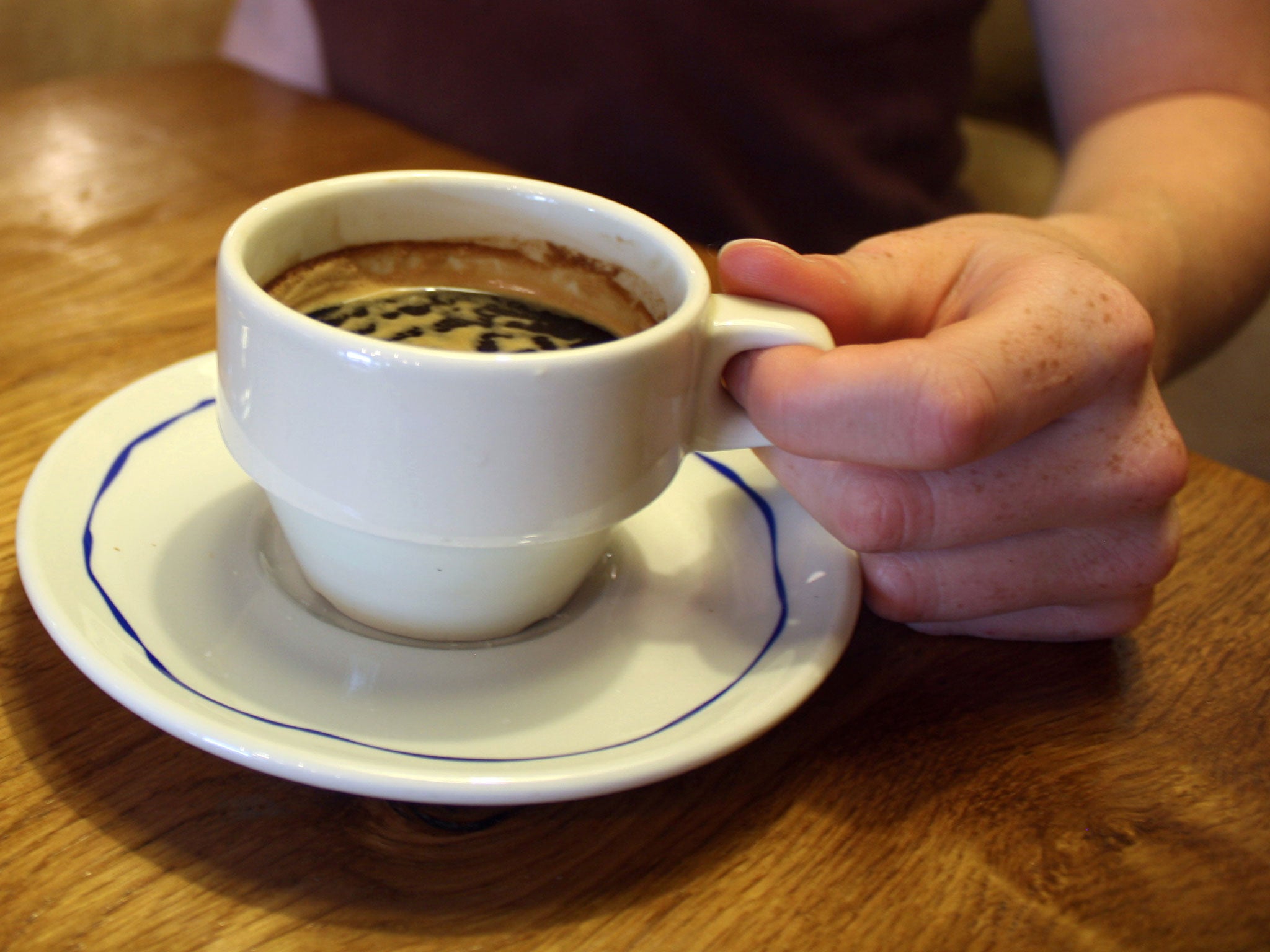 A woman drinks a cup of coffee