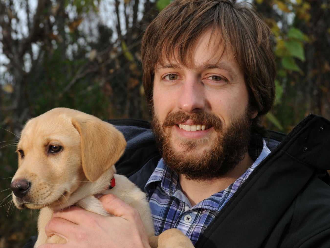 Justin Priest holding his pet Labrador