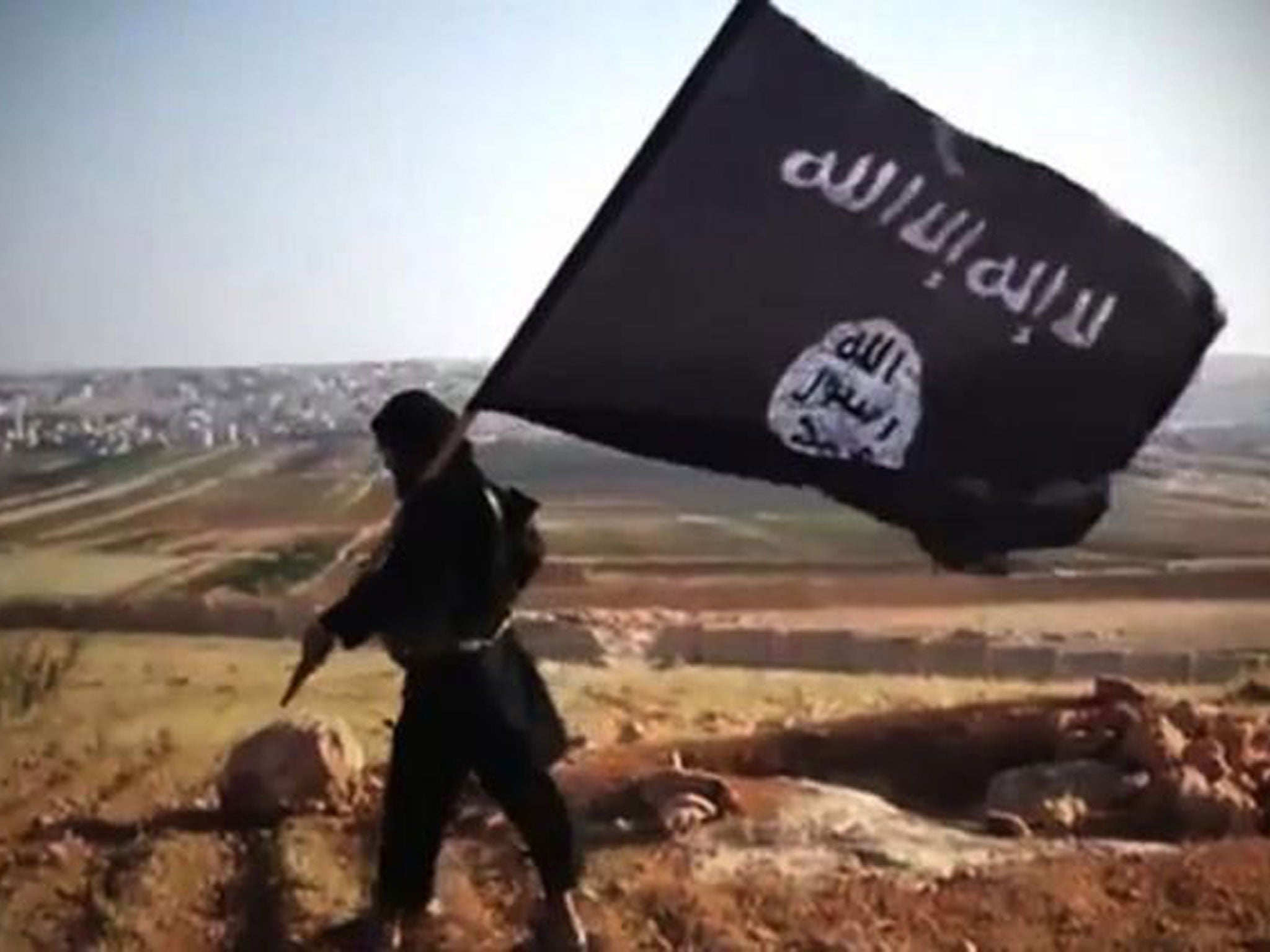 A member of Ussud Al-Anbar, a group that is affiliated to Isis, holding up the black and white flag