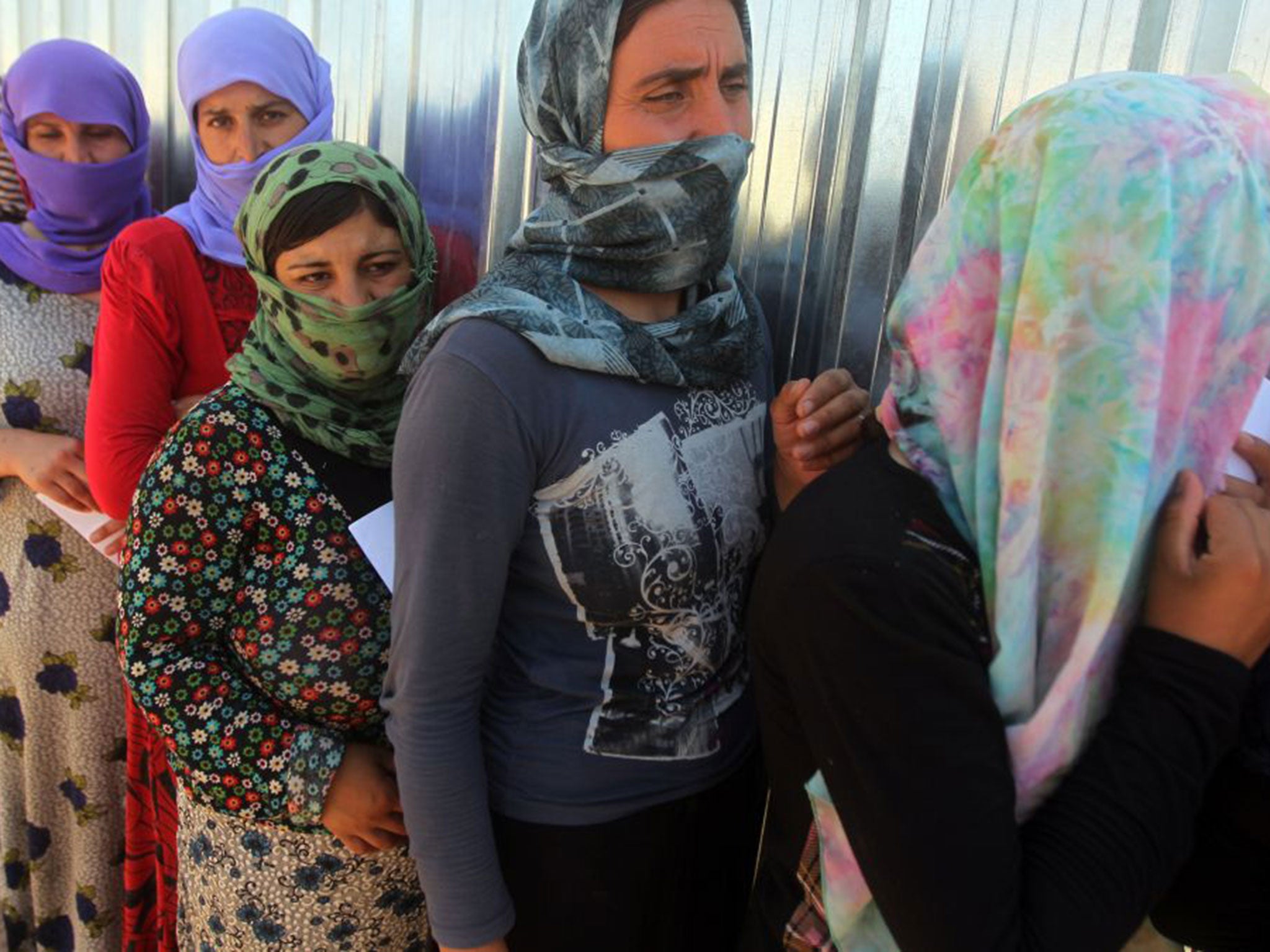 Yazidi women queue for food at the Bajid Kandala camp in Dohuk province, where they took refuge after fleeing the advancing Isis forces. Reports say more than 1,000 are still being held captive