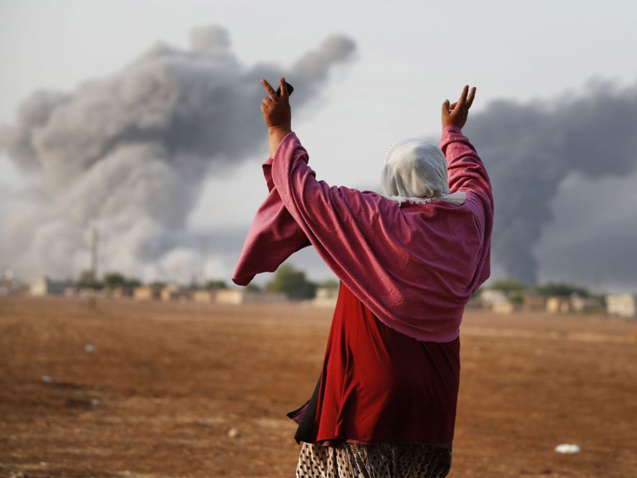 Syrian Kurd Kiymet Ergun takes a defiant stance in the outskirts of Suruc on the Turkey-Syria border