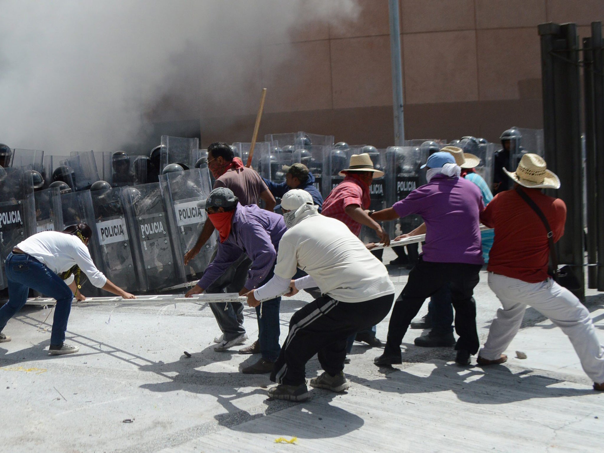 A group of teachers and students and relatives of the 43 Mexican missing students clash with policemen at the Congress of the state of Guerrero to protest the slow advances in the investigation over them, in Chilpancingo, Guerrero. Demonstrators, surround