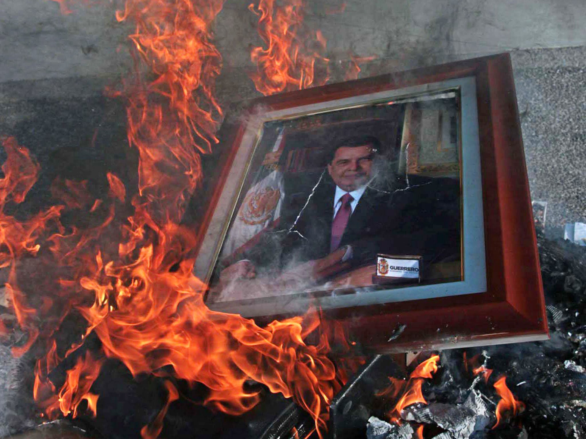 A portrait of Guerrero governor Angel Aguirre Rivero is burnt at the Government palace in Chilpancingo