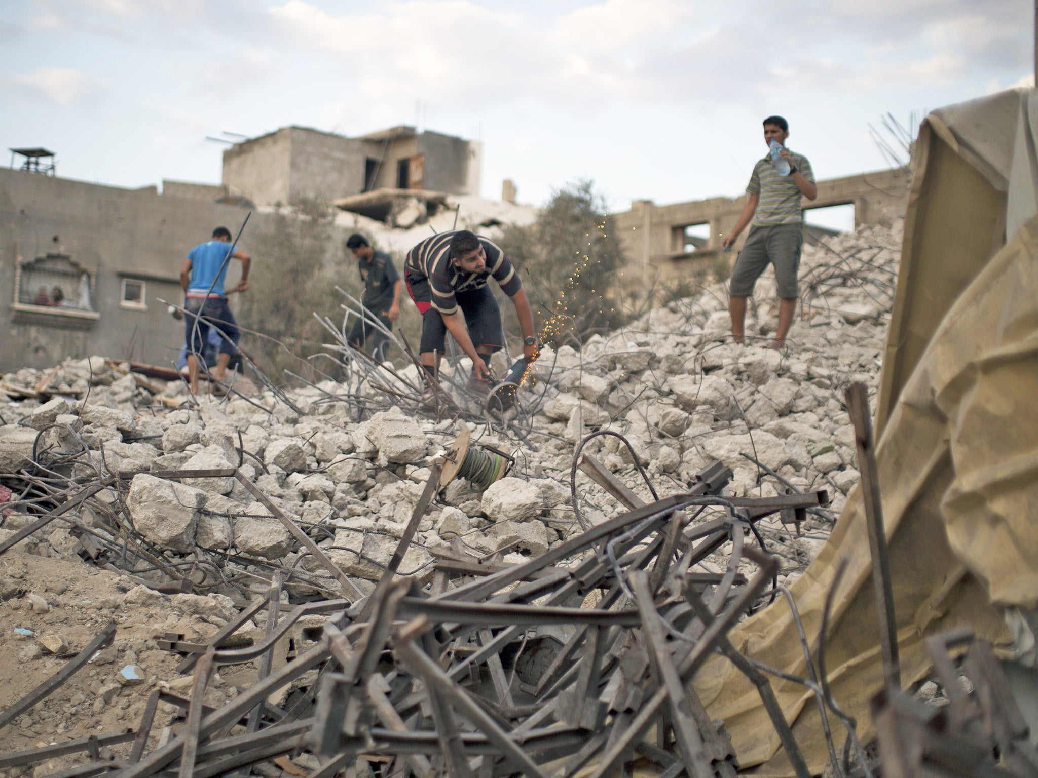 Palestinian men clear debris of homes destroyed during the 50-day conflict between Hamas militants and Israel, in Shejaiya neighbourhood, Gaza city (Getty)