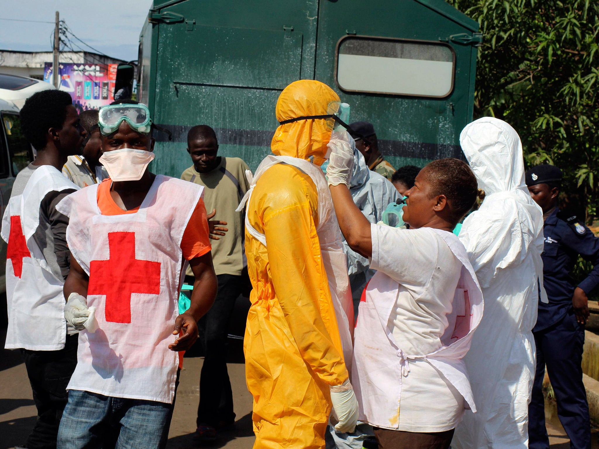 A health worker fixes another health worker's protective suit in the Aberdeen district of Freetown, Sierra Leone