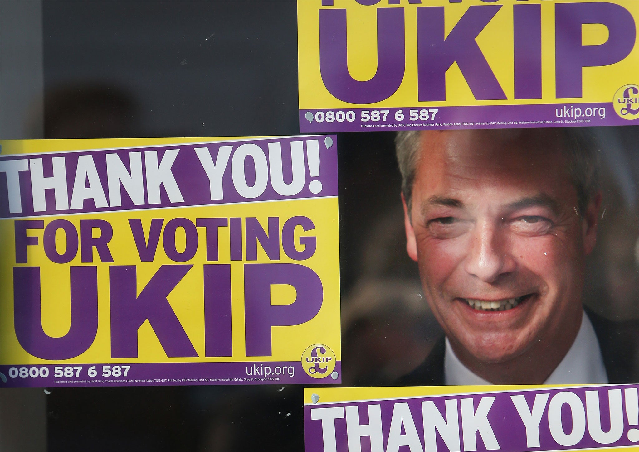 Nigel farage poses for photographs at party headquarters after Douglas Carswell won the Clacton-on-Sea by-election for UKIP