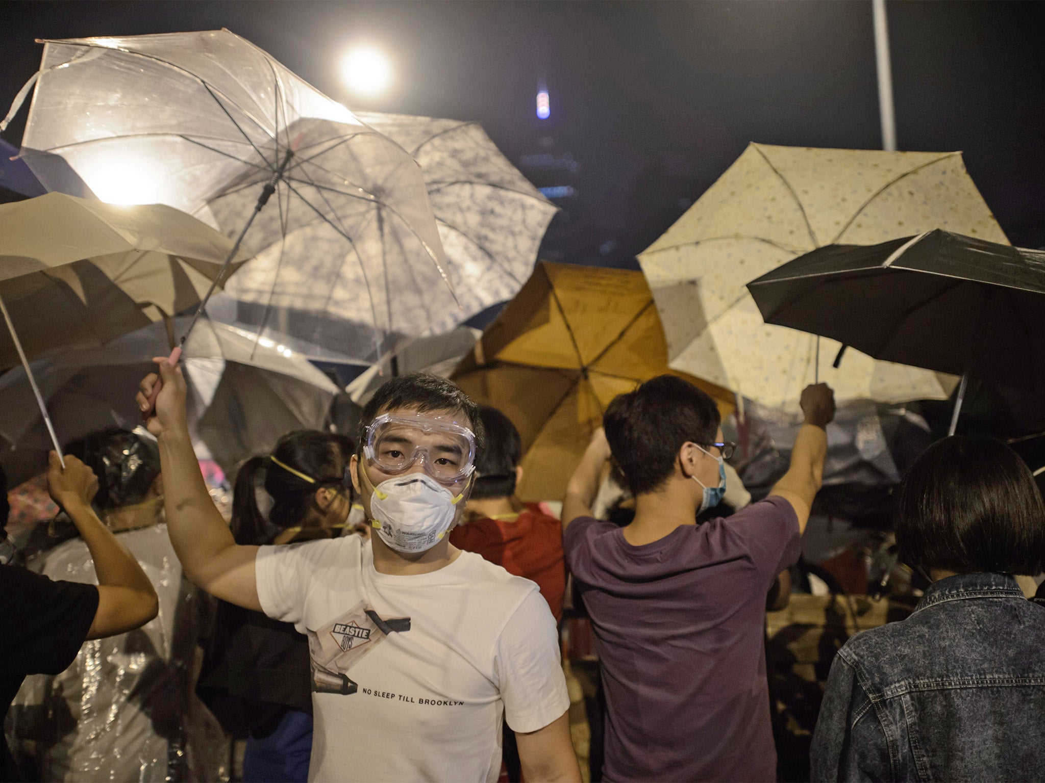 Pro-democracy protesters bracing themselves on a road outside the central government offices in the Admiralty district as police march towards them