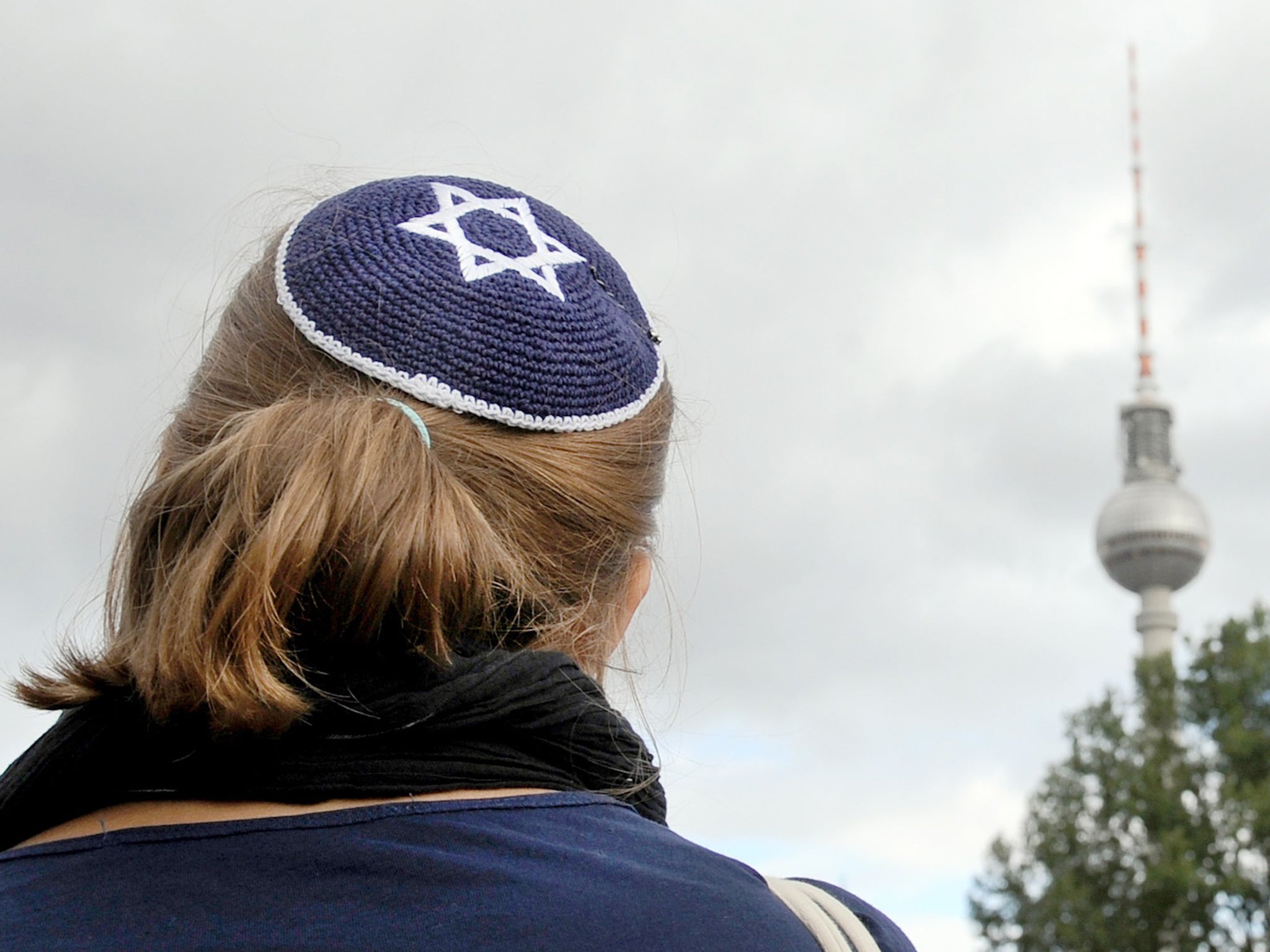 A woman wears a kippah, the traditional Jewish headdress, as she takes part in a demonstration in Berlin