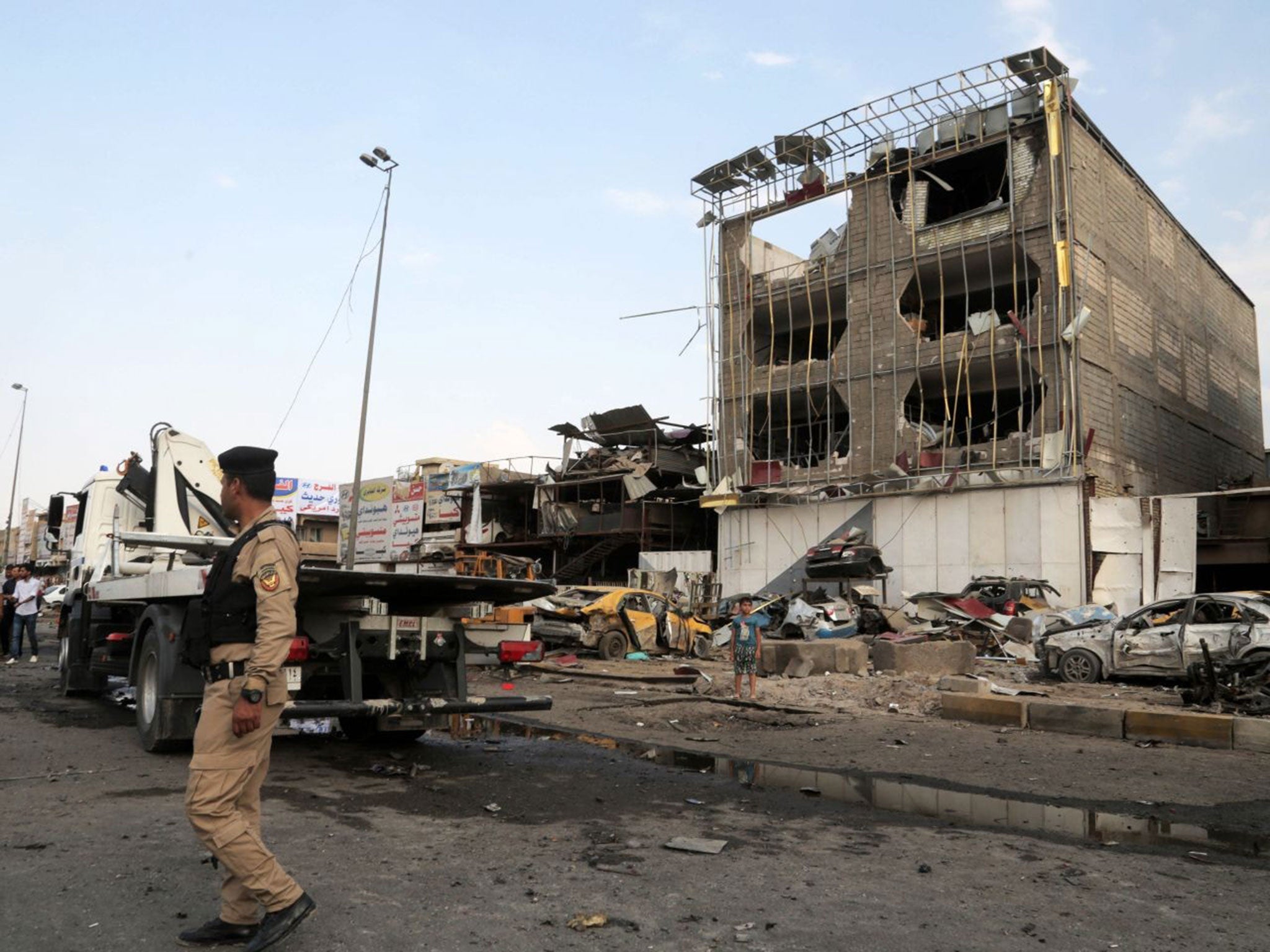 Security forces inspect the site of a car bomb explosion in the largely Shia district of Talibiyah in Baghdad