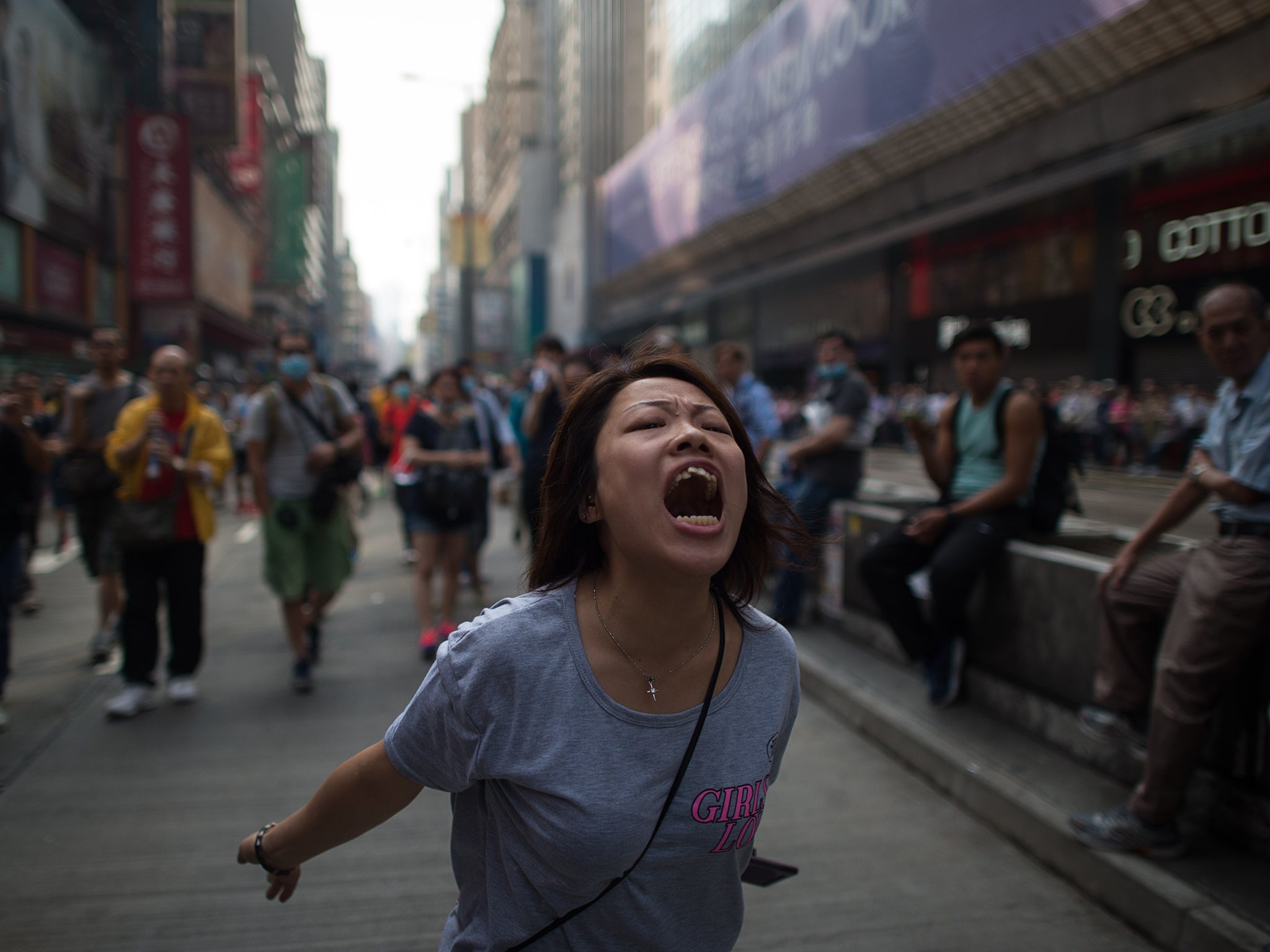 A pro-democracy protester shouts towards police after efforts to clear them from an area they were occupying in the Mong Kok shopping district of Hong Kong failed