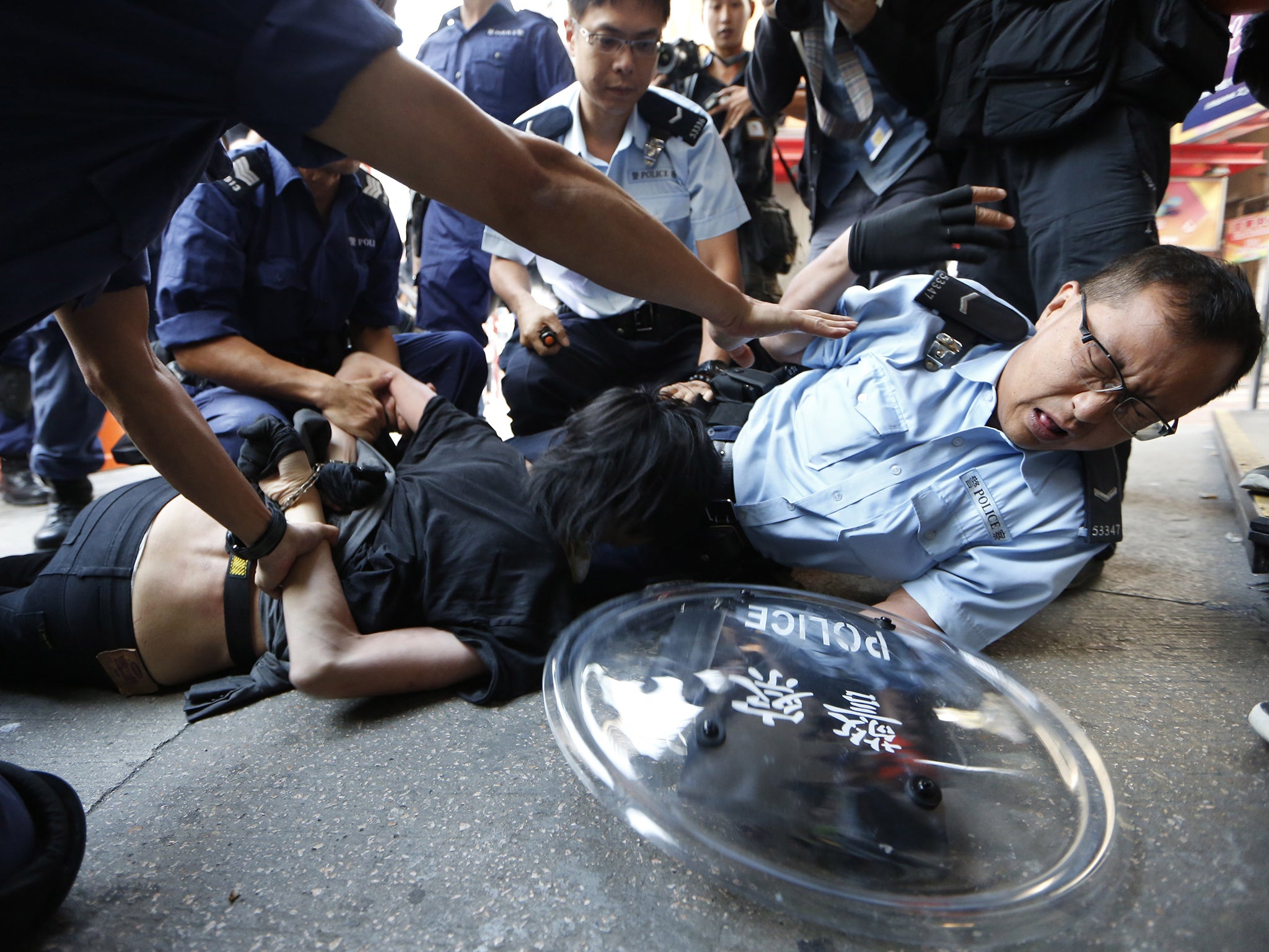 A protester is arrested by riot police after the force moved into an occupied area at Mong Kok shopping district