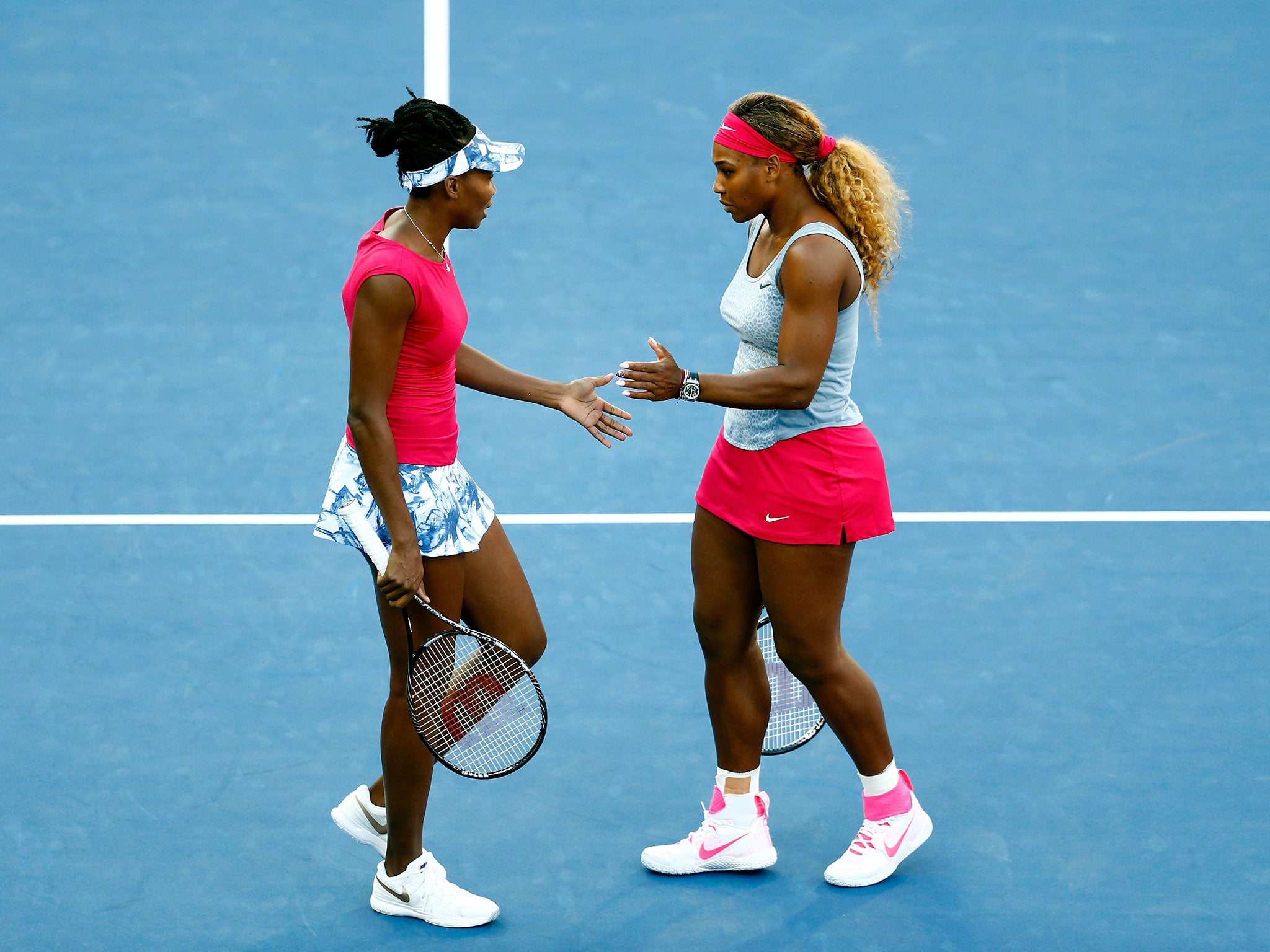Serena Williams and Venus Williams play in a women's doubles match at the 2014 US Open