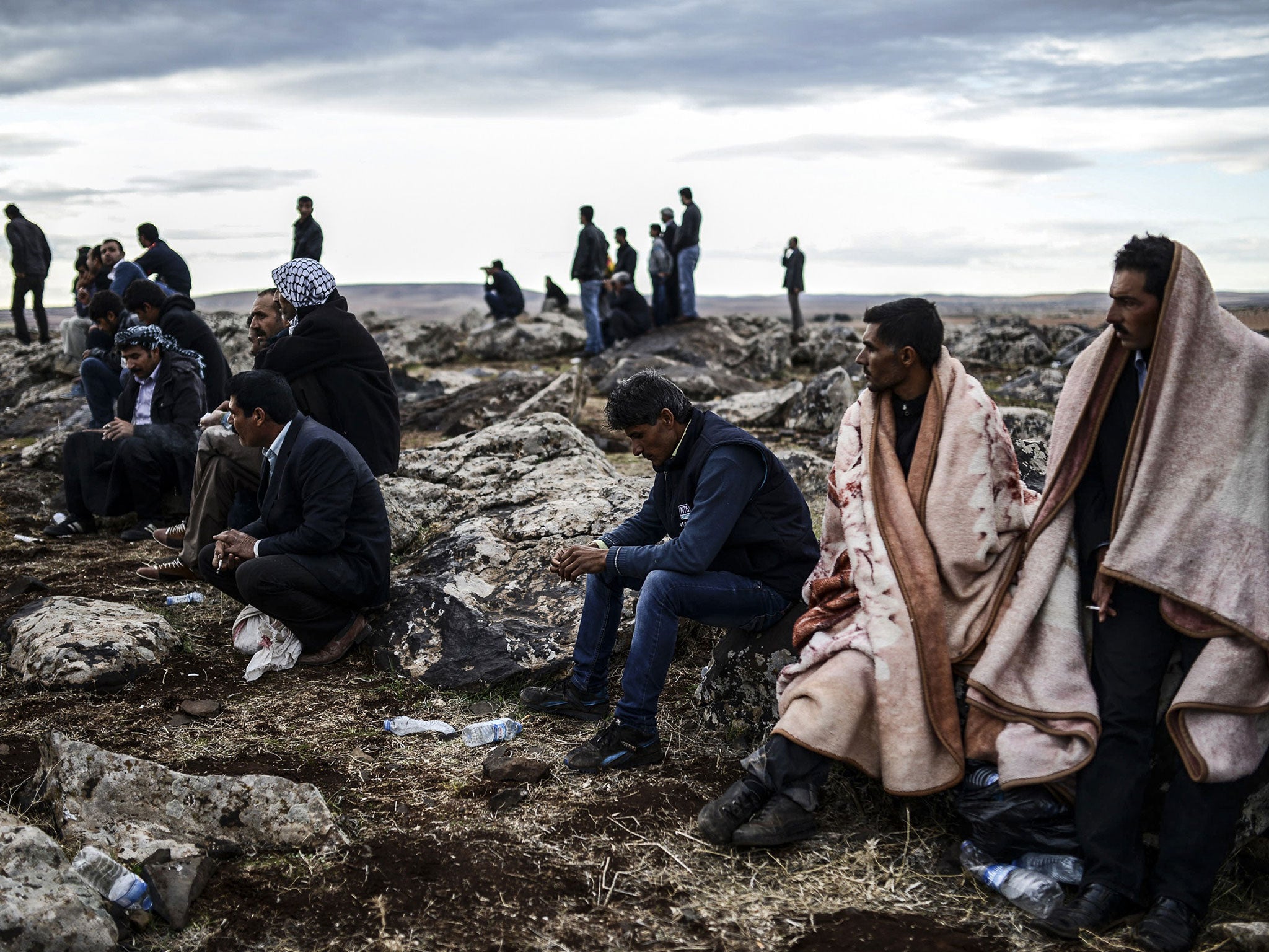 Kurdish people watch the battle rage in the Syrian town of Kobani from the Turkish border in the south-eastern village of Mursitpinar, where many have fled as Isis advanced