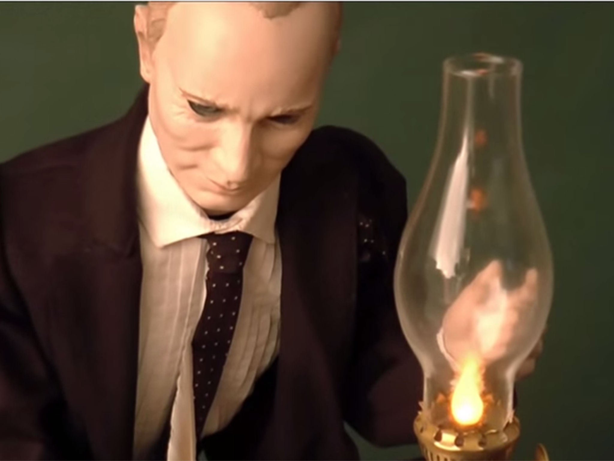 The doll, shown here in a video released by the auction house, wears a tiny blue wool suit and hand-sewn leather shoes