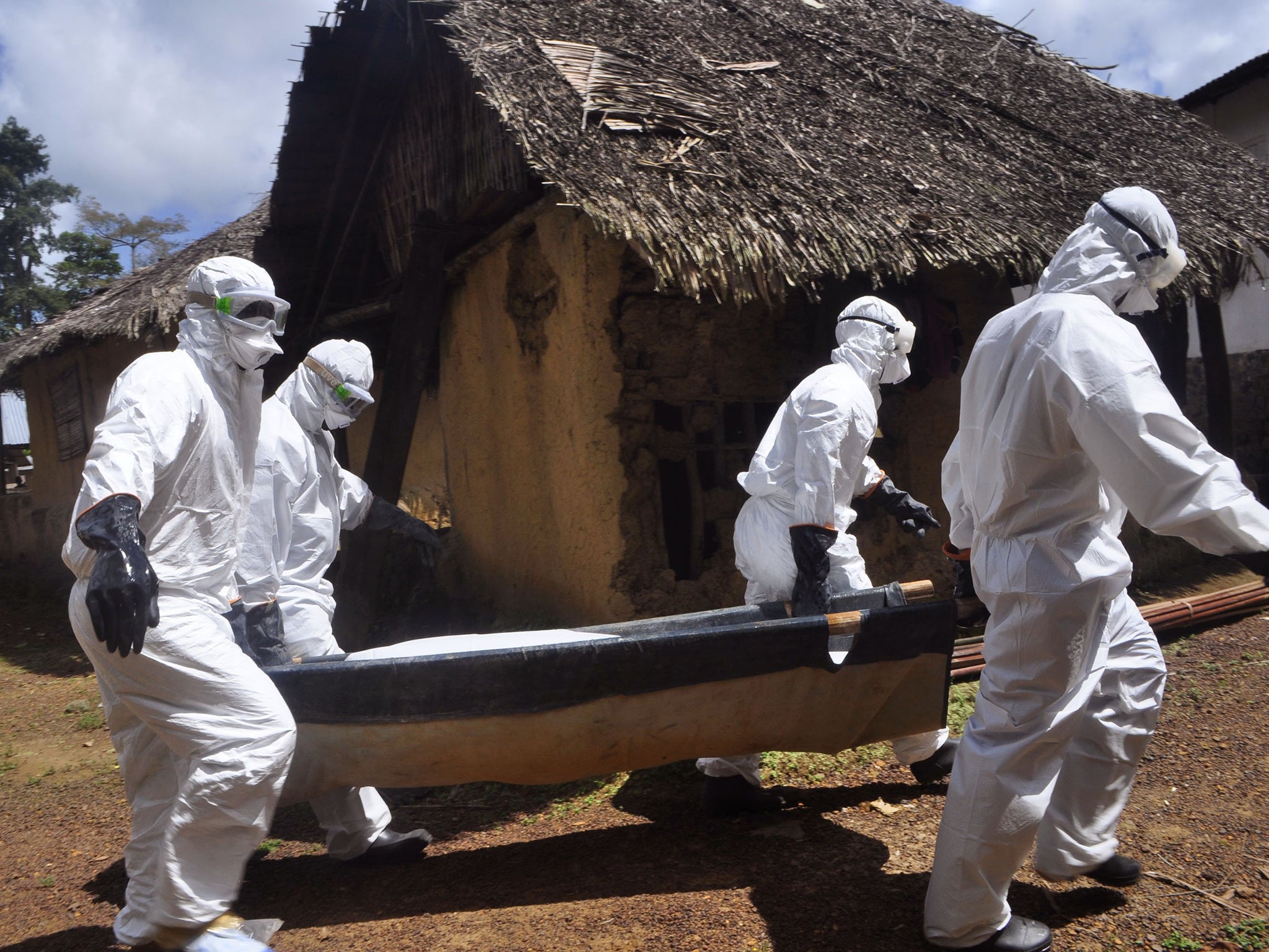 Health workers carry the body of a suspected Ebola victim in Bomi county on the outskirts of Monrovia, Liberia