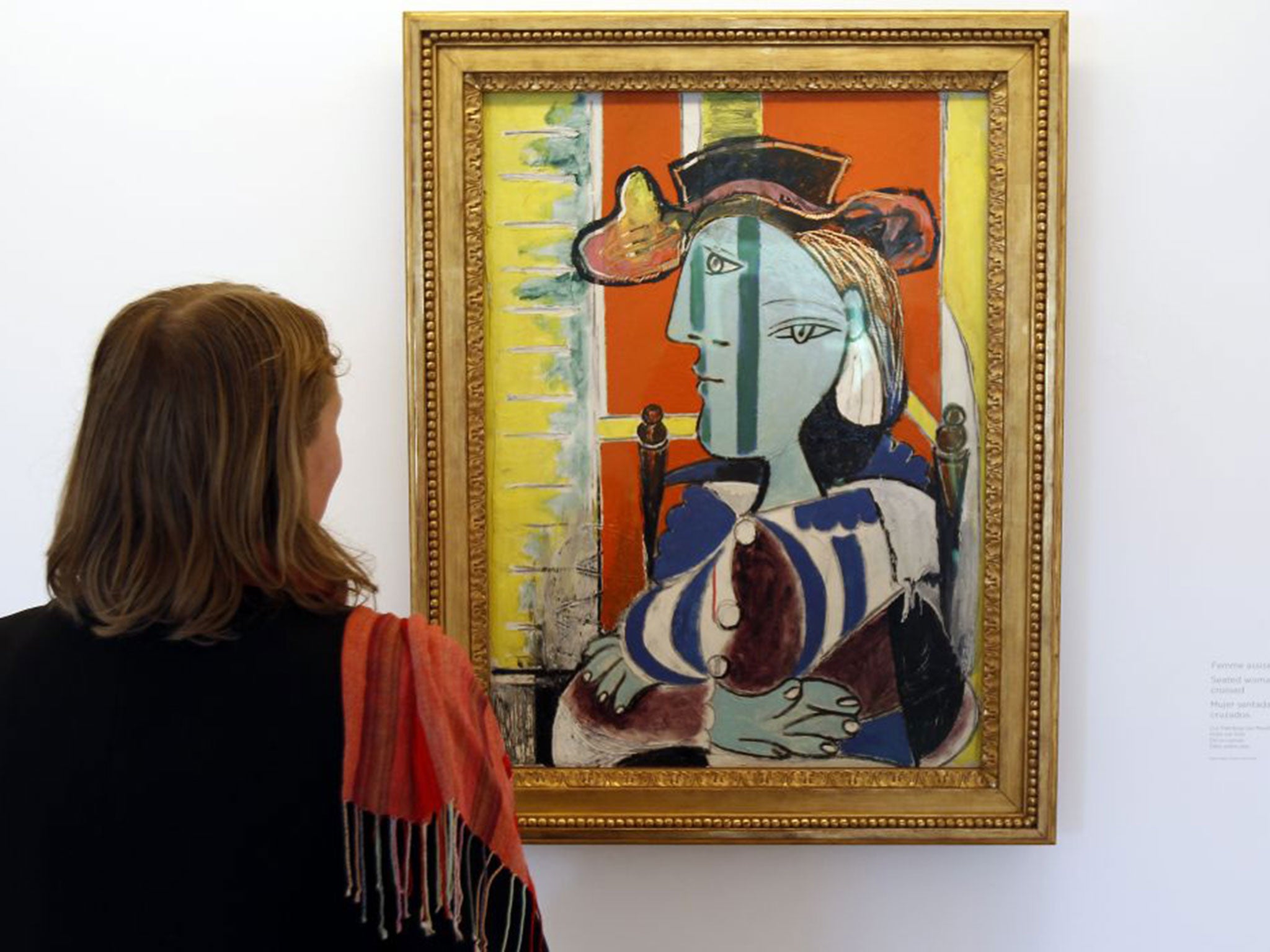 A visitor takes in Seated Woman With Arms Crossed at Musée Picasso