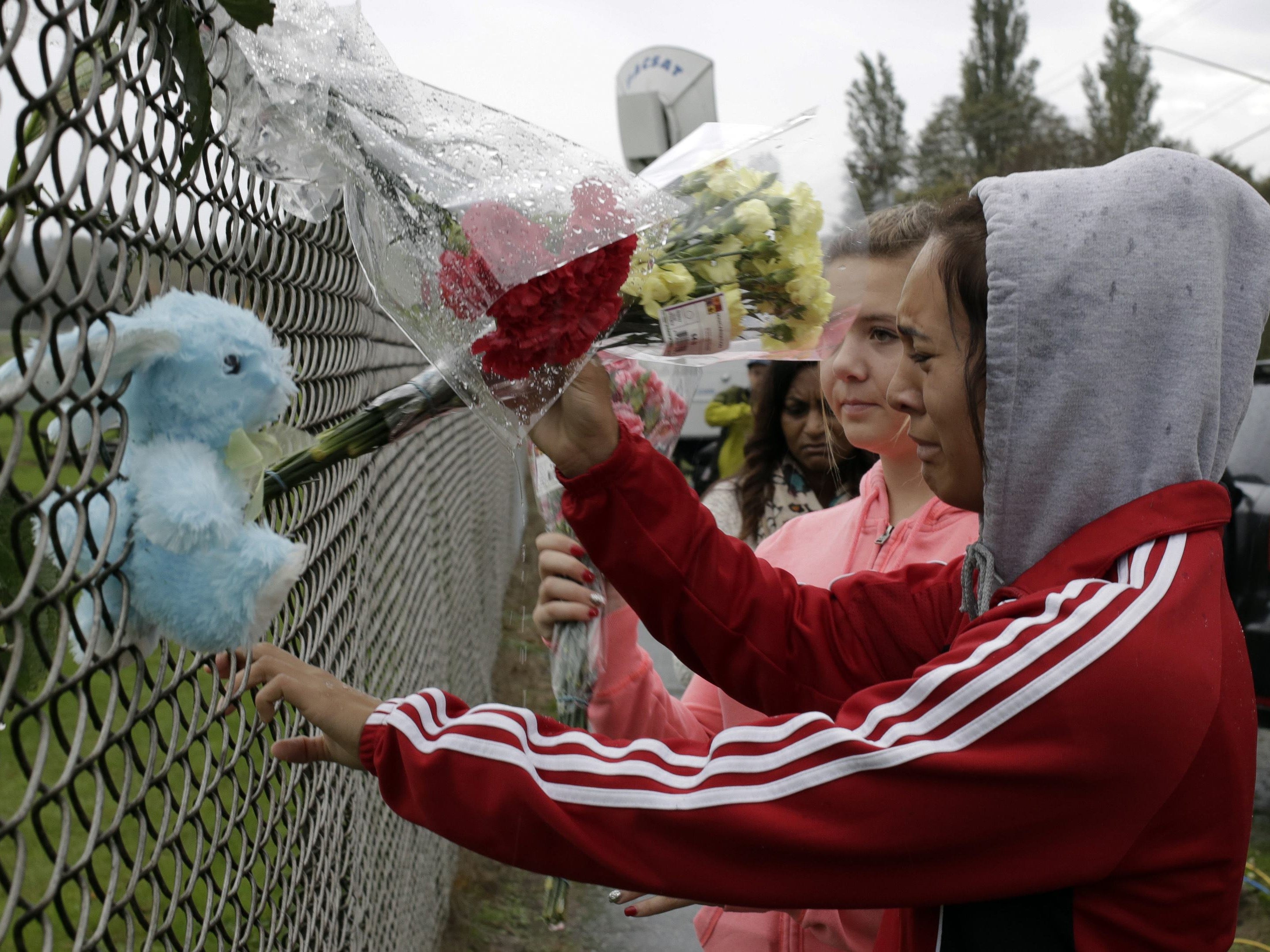 A student places flowers outside Marysville-Pilchuck High School