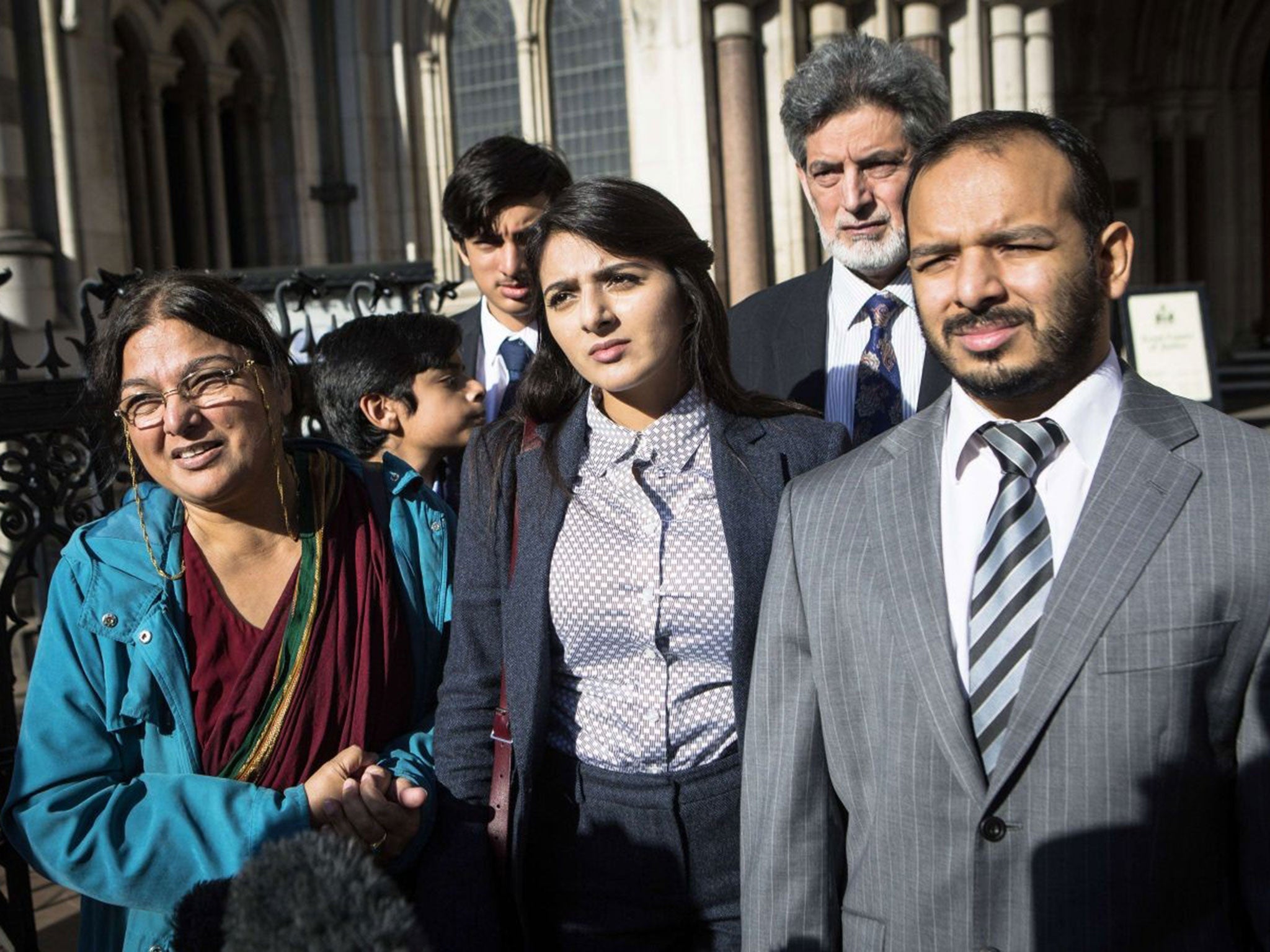 Dr Kan's mother Fatima (L), sister Sara (C) and brother Afoze (R), outside the Royal Courts of Justice on 27 Oct