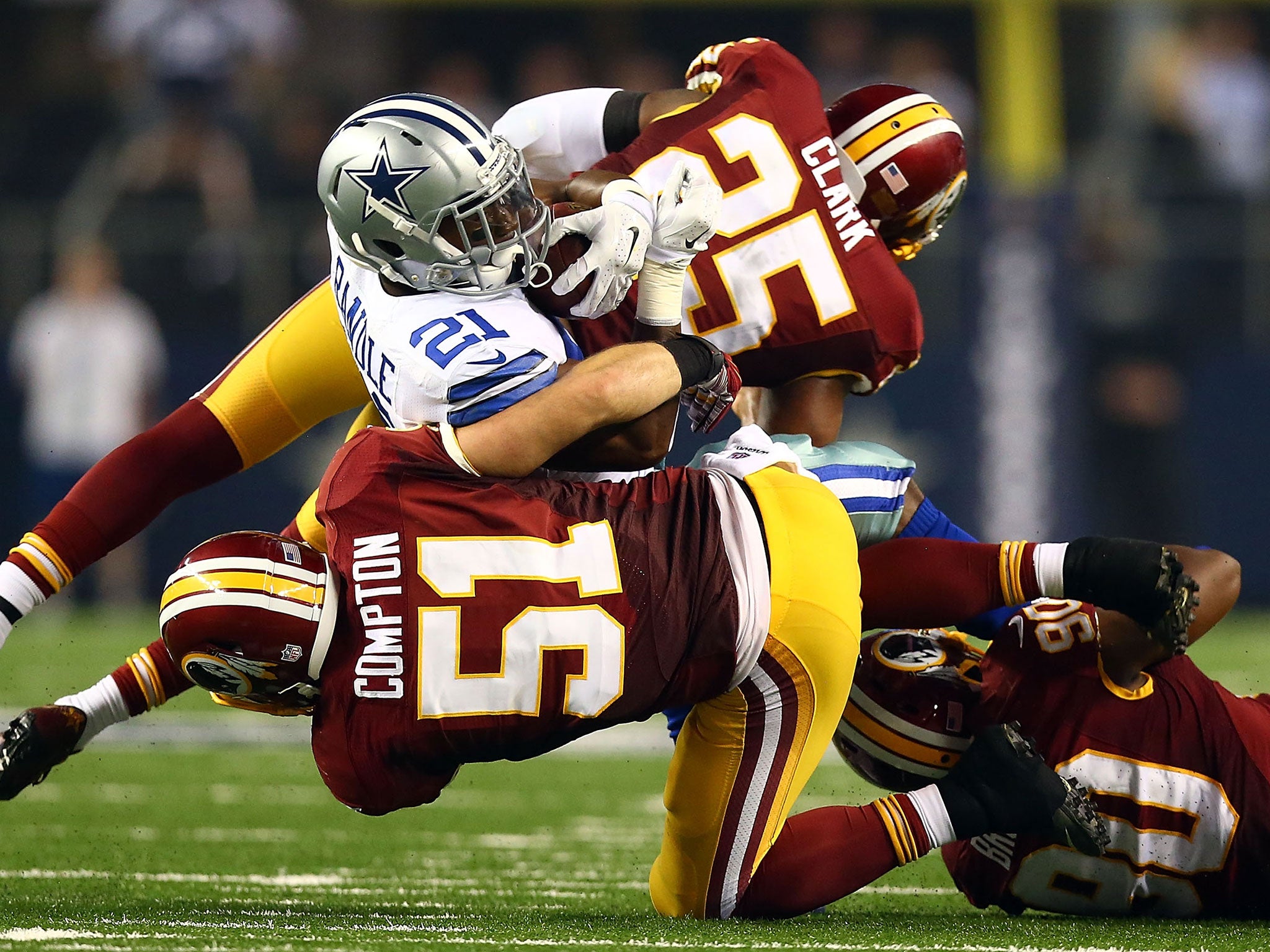 Joseph Randle of the Dallas Cowboys is tackled by Everette Brown and Ryan Clark